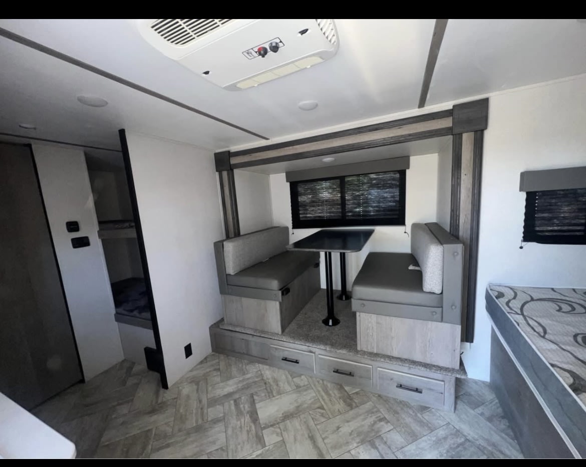 This RV rental interior features a cozy dinette, bunk beds, and a comfy sleeping area, perfect for your next road trip adventure.. Keystone RV Springdale 2021