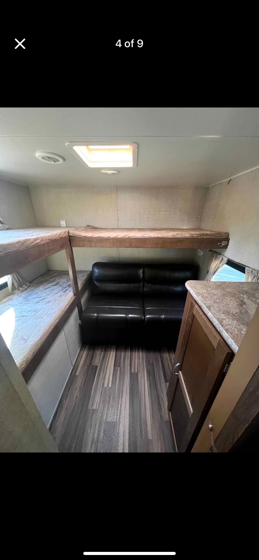 RV rental interior: L-shaped bunk beds, a sofa, and wood flooring create a functional and cozy living space.. Gulf Stream Conquest 2017