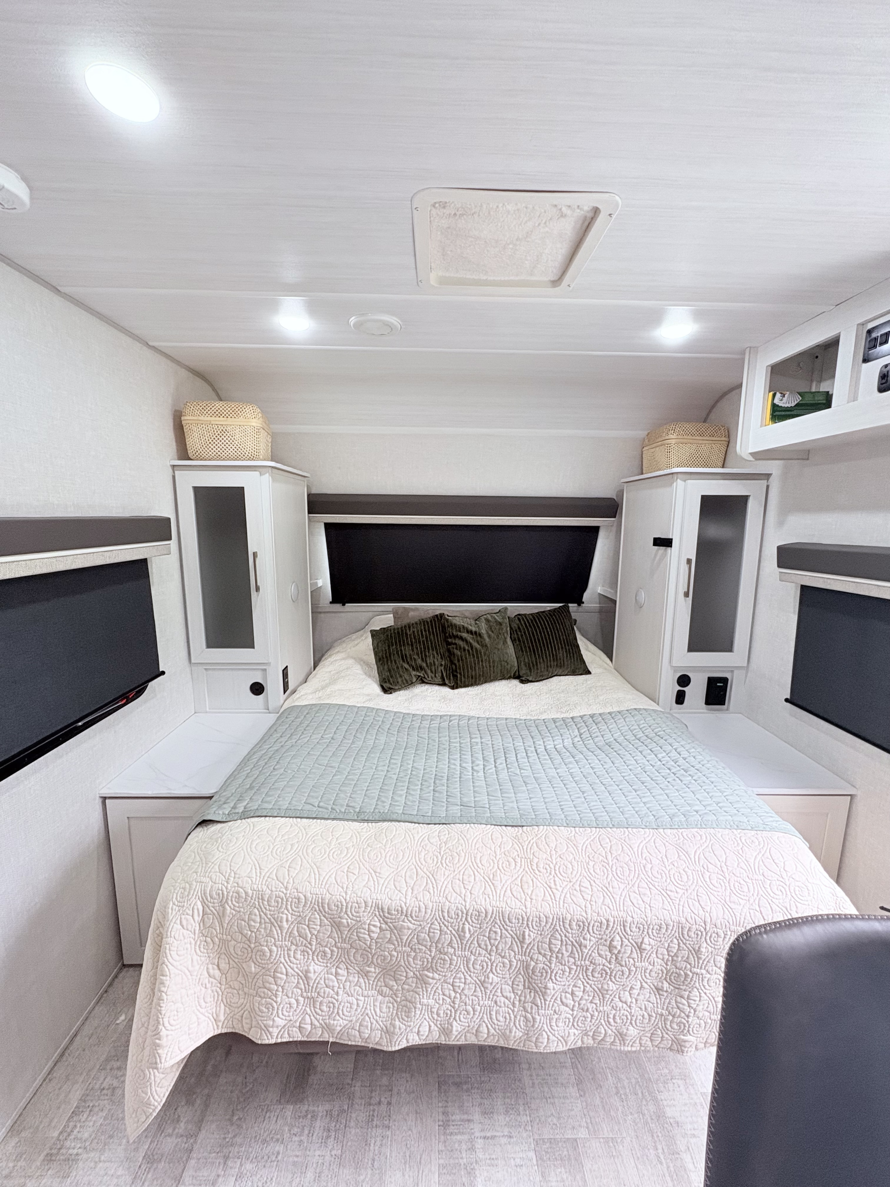 Cozy RV rental bedroom with a queen bed, modern built-in storage, bright lights, and light wood-look flooring.. Forest River NoBo 20.3 2025