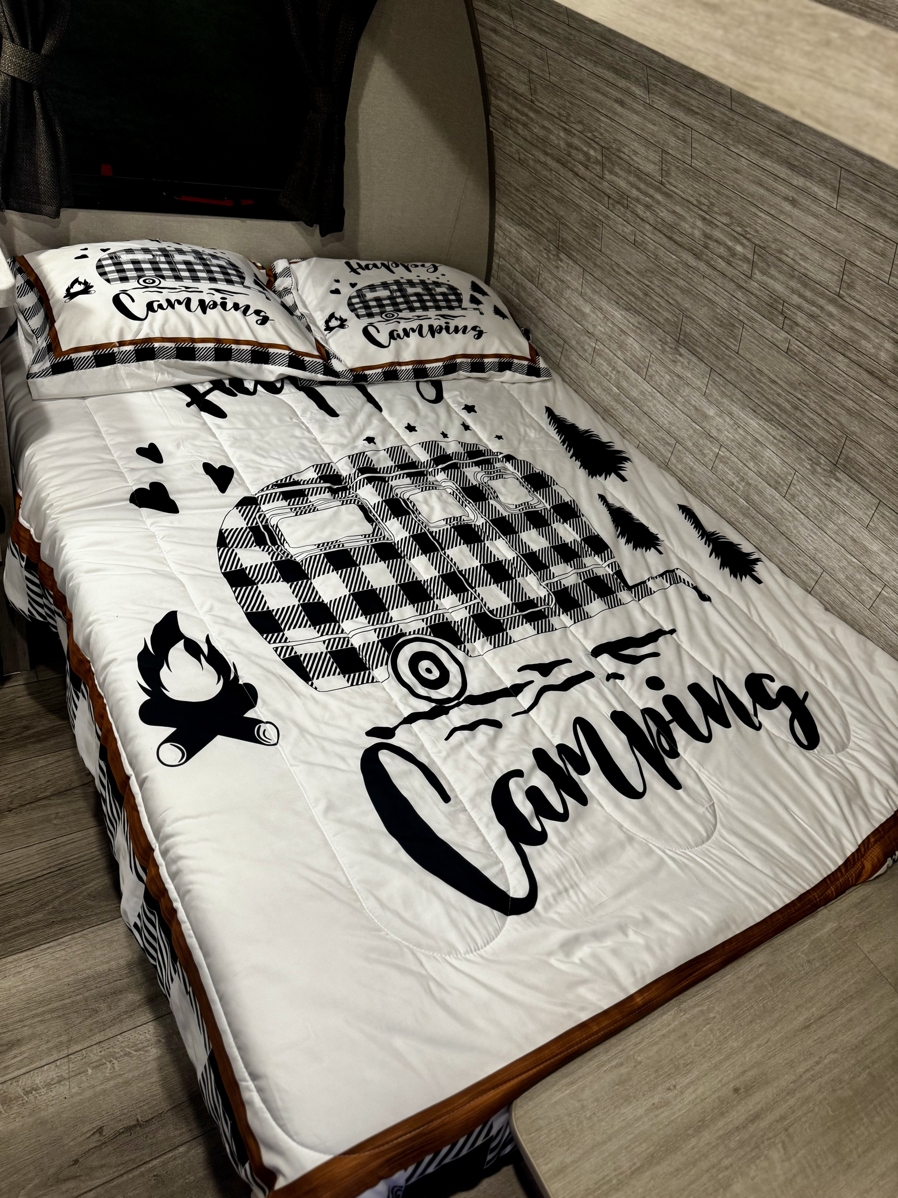 Camping-themed bedding with a plaid RV, trees, and campfire in a cozy RV rental.. Forest River Coachmen Catalina 134BHX 2025