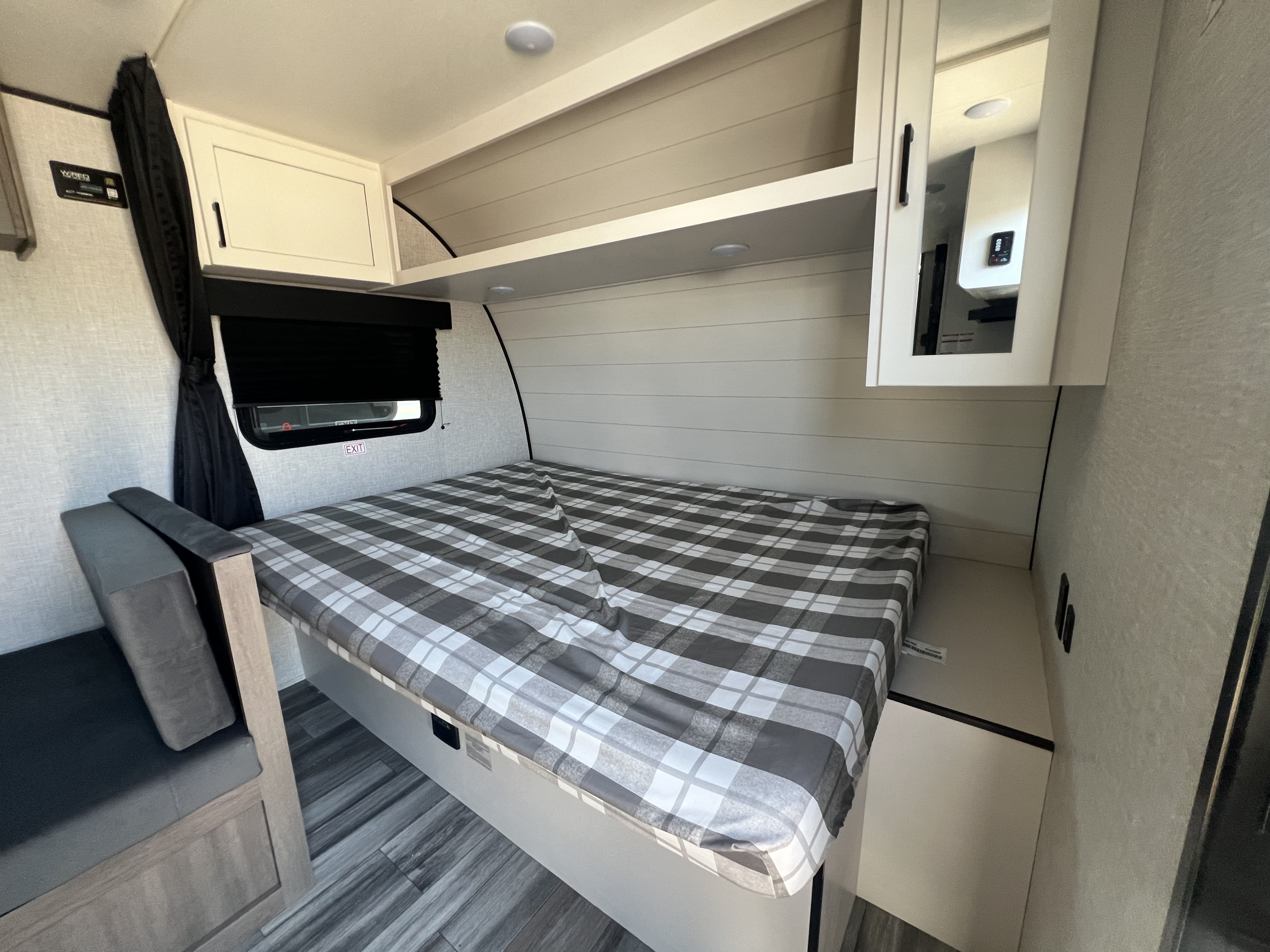 Inside an RV rental: Compact bedroom with plaid bed, modern cabinets, and cozy bench.. Jayco Jay Flight SLX 175 BH 2025