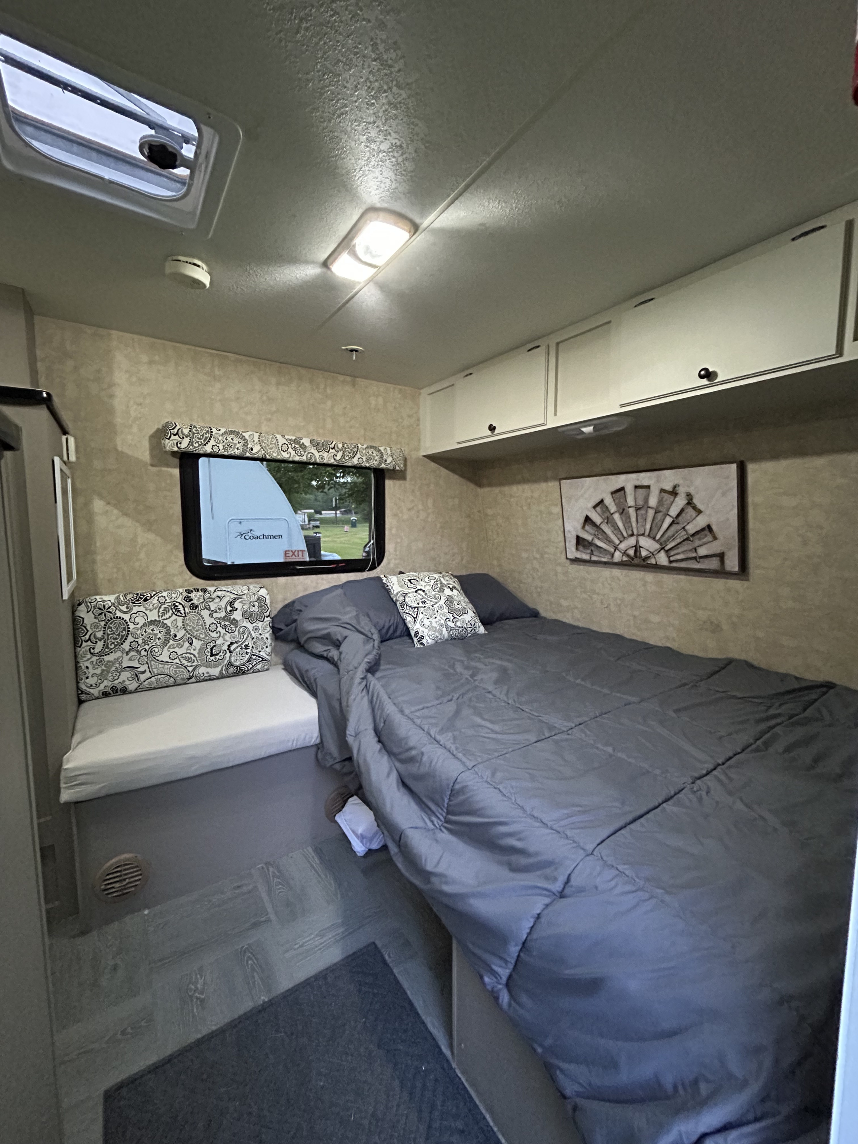 Inviting RV rental bedroom with a comfy bed, bench seating, overhead storage, and a scenic window view.. KZ-RV SPORTSMEN CLASSIC 14RK 2010