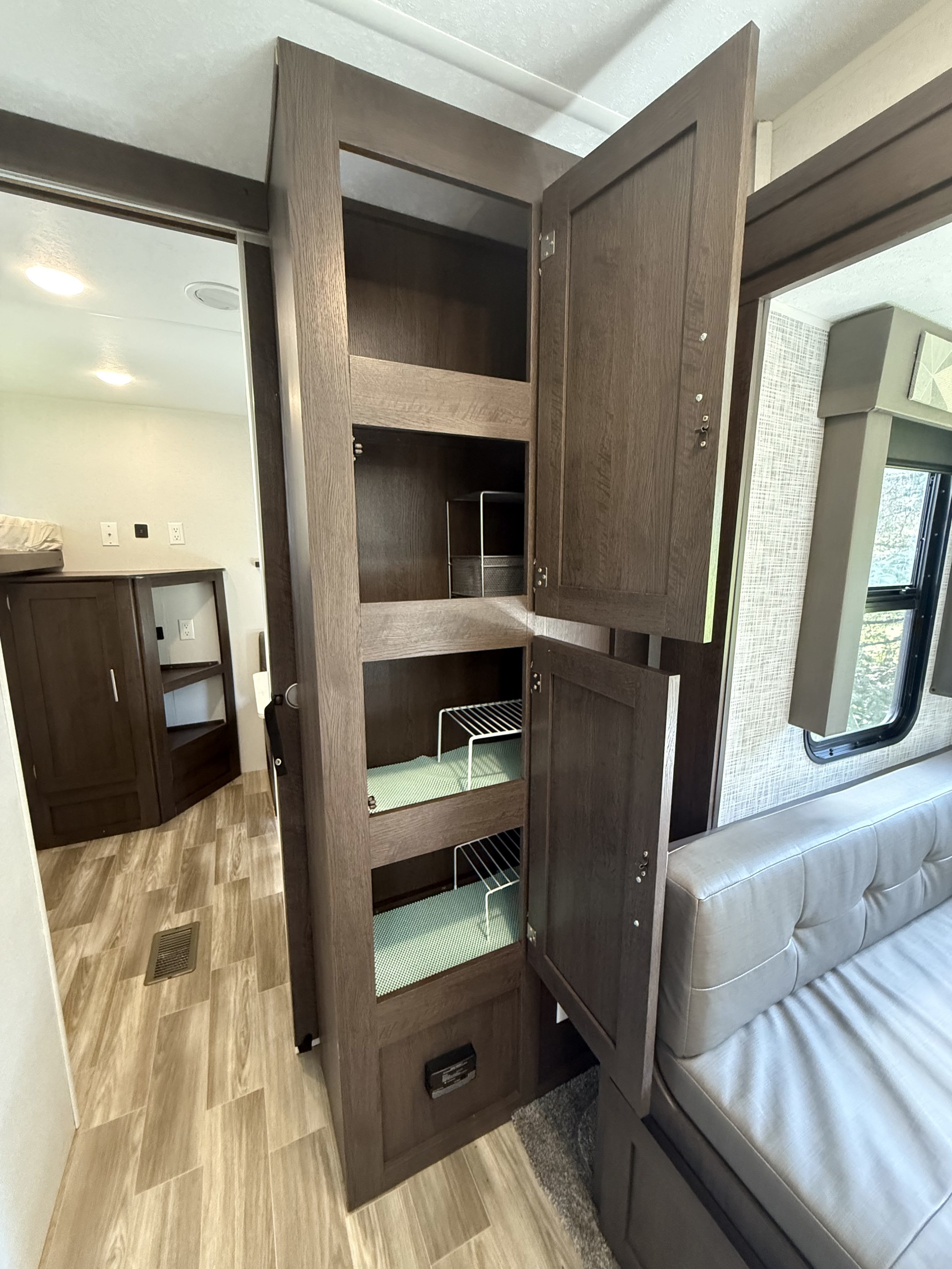 Efficient RV rental interior with a spacious pantry cabinet, organized shelves, and a comfortable dinette area.. Forest River Salem 2019