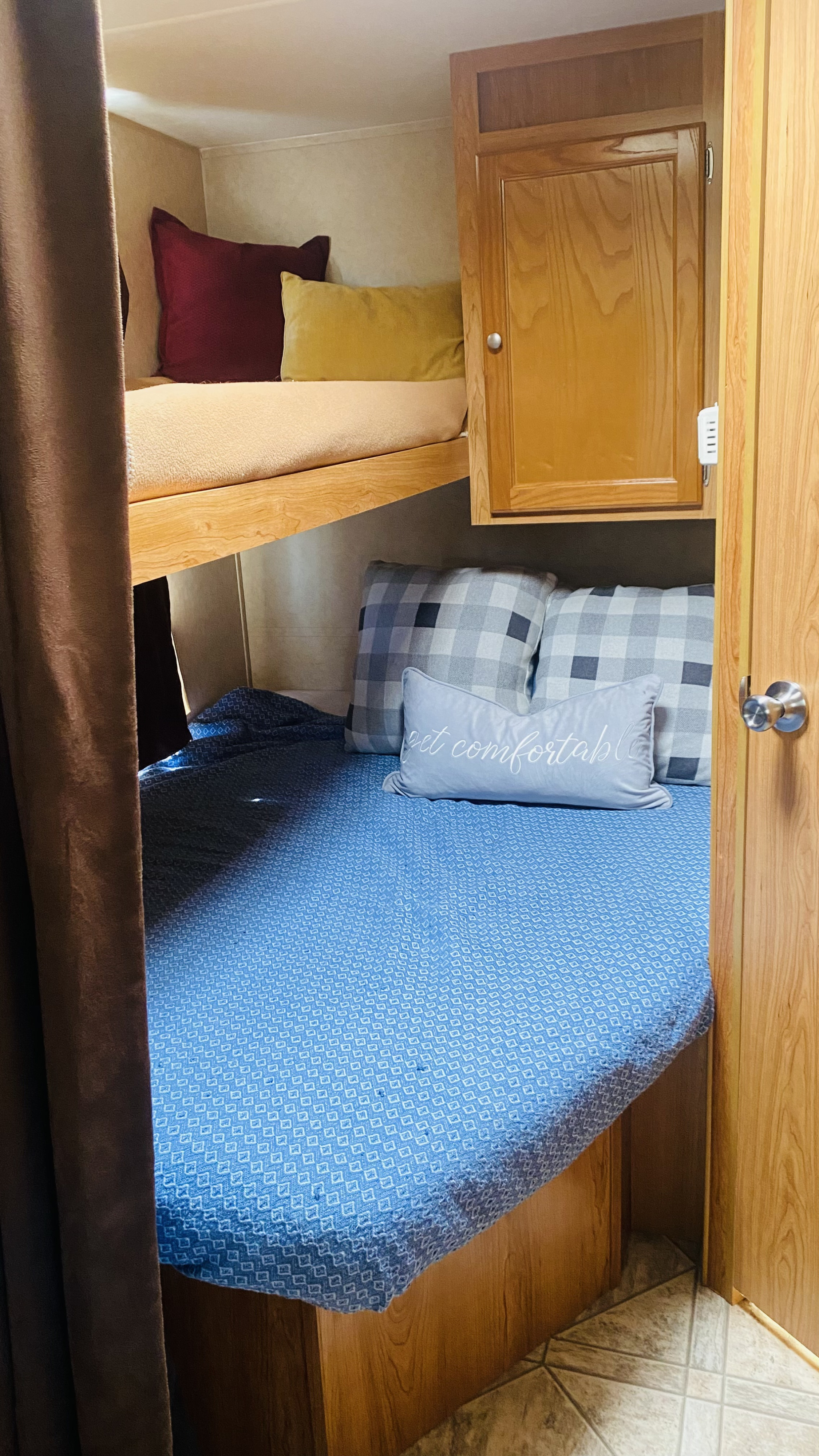Inside an RV rental: a cozy bunk bed area with soft bedding, pillows, and a built-in cabinet.. R-Vision Trail-Sport 2010