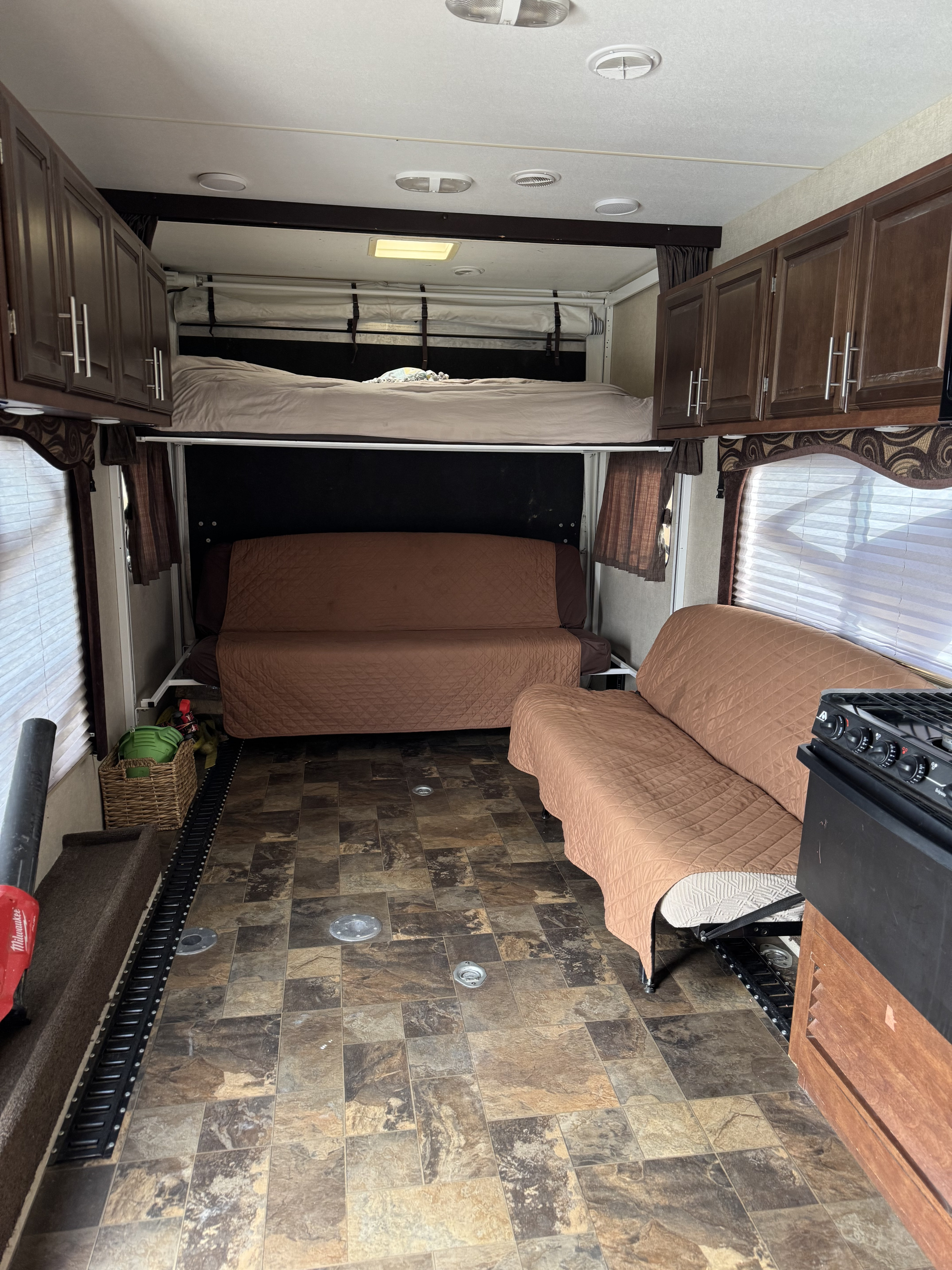 Spacious RV rental interior featuring a power bunk bed, convertible sofas, and durable flooring with cargo tie-downs.. Eclipse Recreational Vehicles Attitude 2013