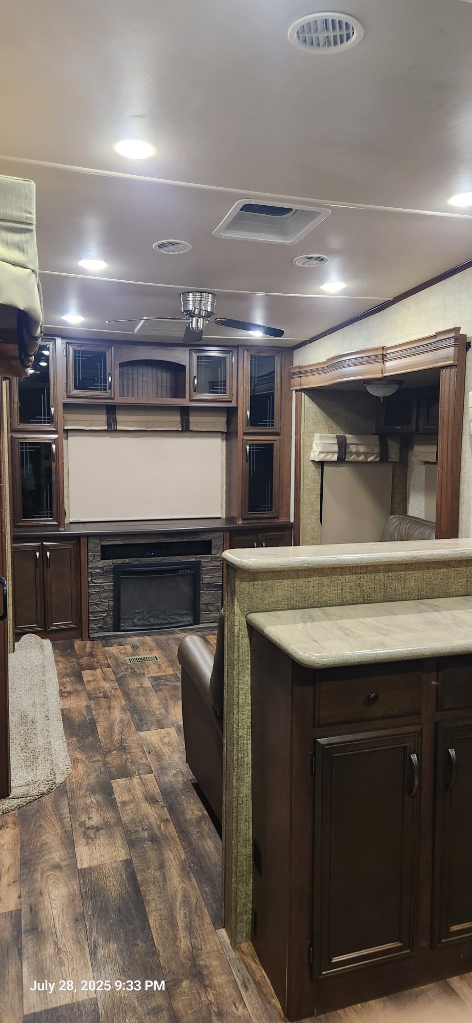 Spacious RV rental interior featuring a cozy living area with fireplace, TV, and modern kitchen counter.. Forest River Sandpiper 2017