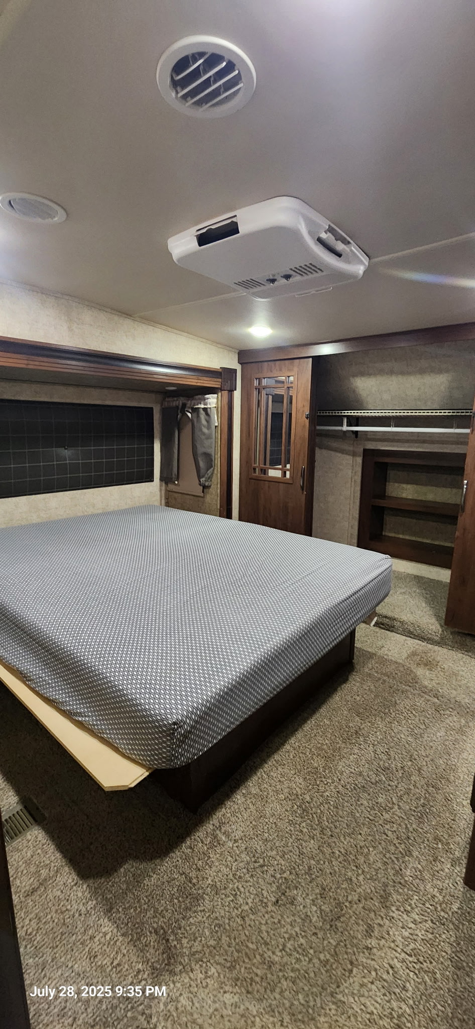 Spacious RV rental bedroom with a comfy bed, ceiling AC, and ample closet storage.. Forest River Sandpiper 2017