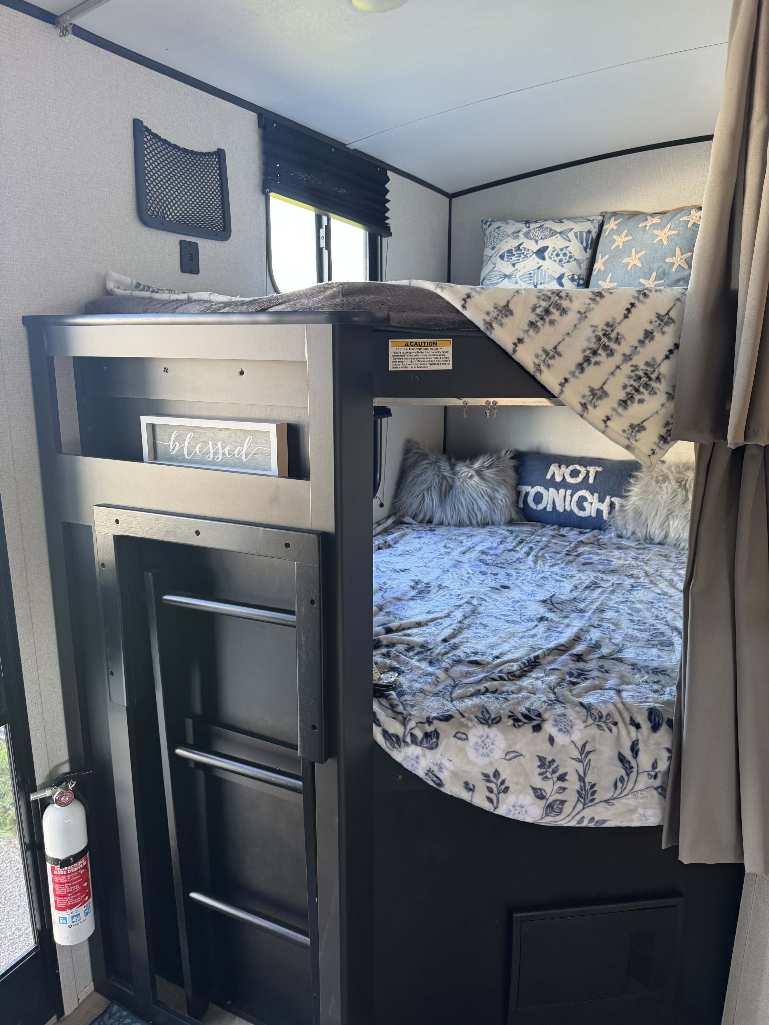 Cozy RV rental interior showcasing comfortable bunk beds, ideal for travel. Includes decor & safety features.. Keystone RV Springdale 2022