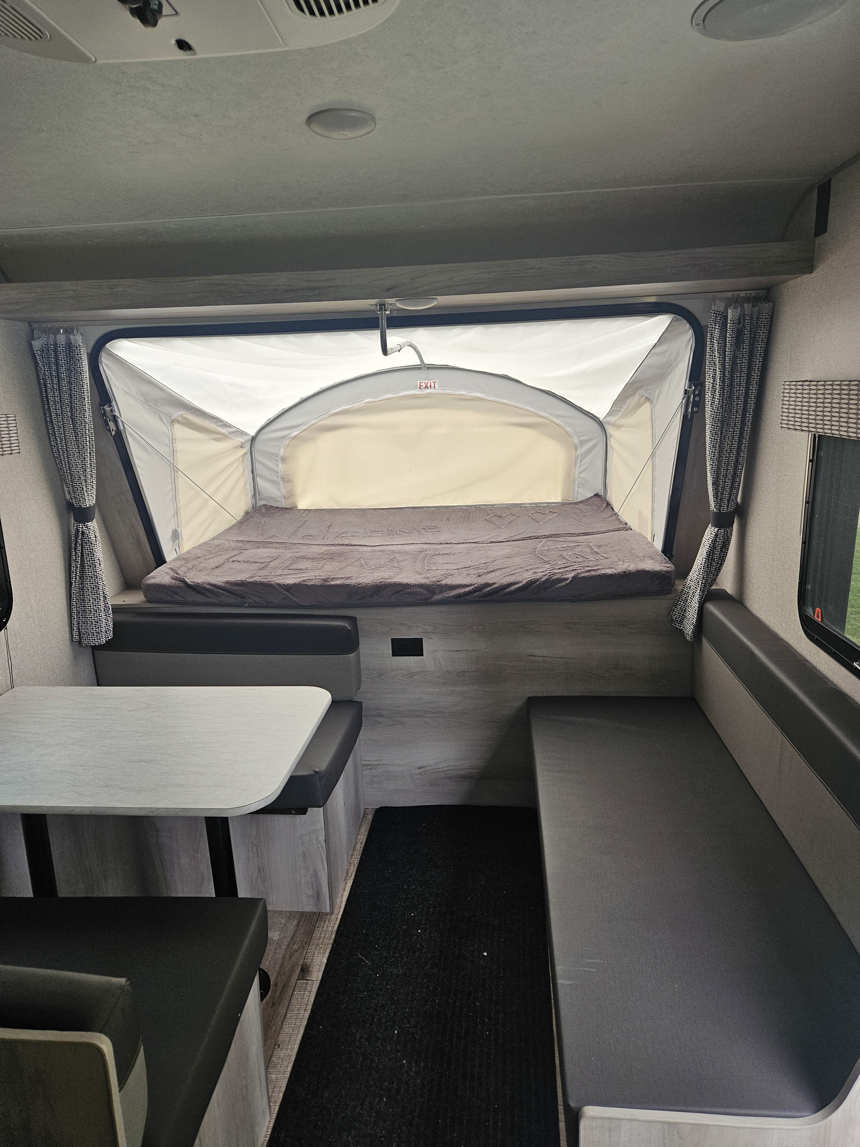 Explore this RV rental's inviting interior featuring a pop-out bed, dinette, and spacious bench seating.. Sportsmen Classic 2022