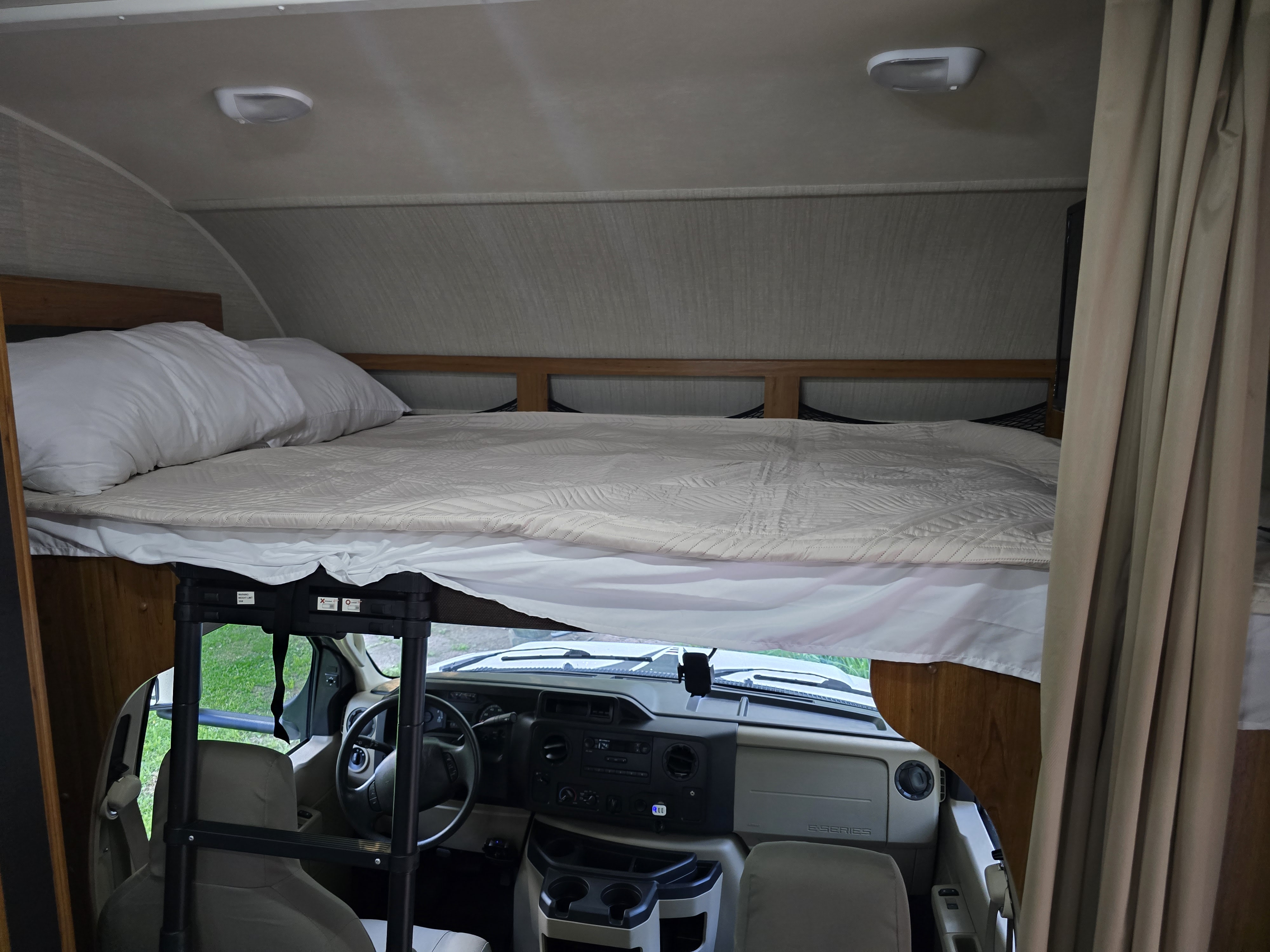 RV rental: View inside a comfortable RV showing a large cabover bed and the vehicle's cockpit. Ready for travel!. Jayco Redhawk 2017