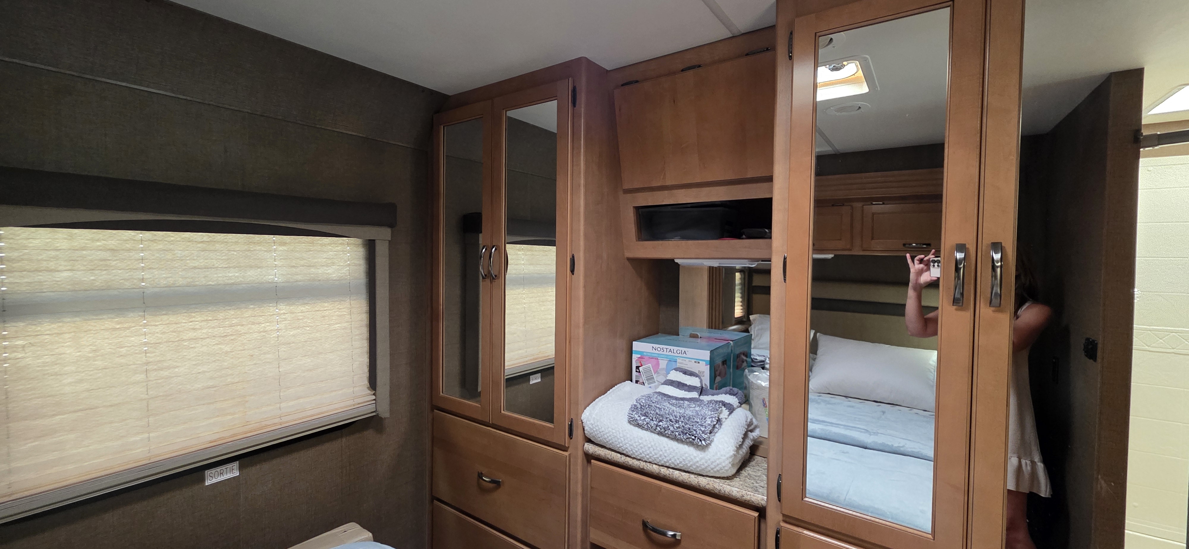 Cozy RV rental bedroom with mirrored cabinets reflecting a comfortable bed. Perfect for your next road trip adventure.. A.C.E. A.C.E. Motorhome 2015
