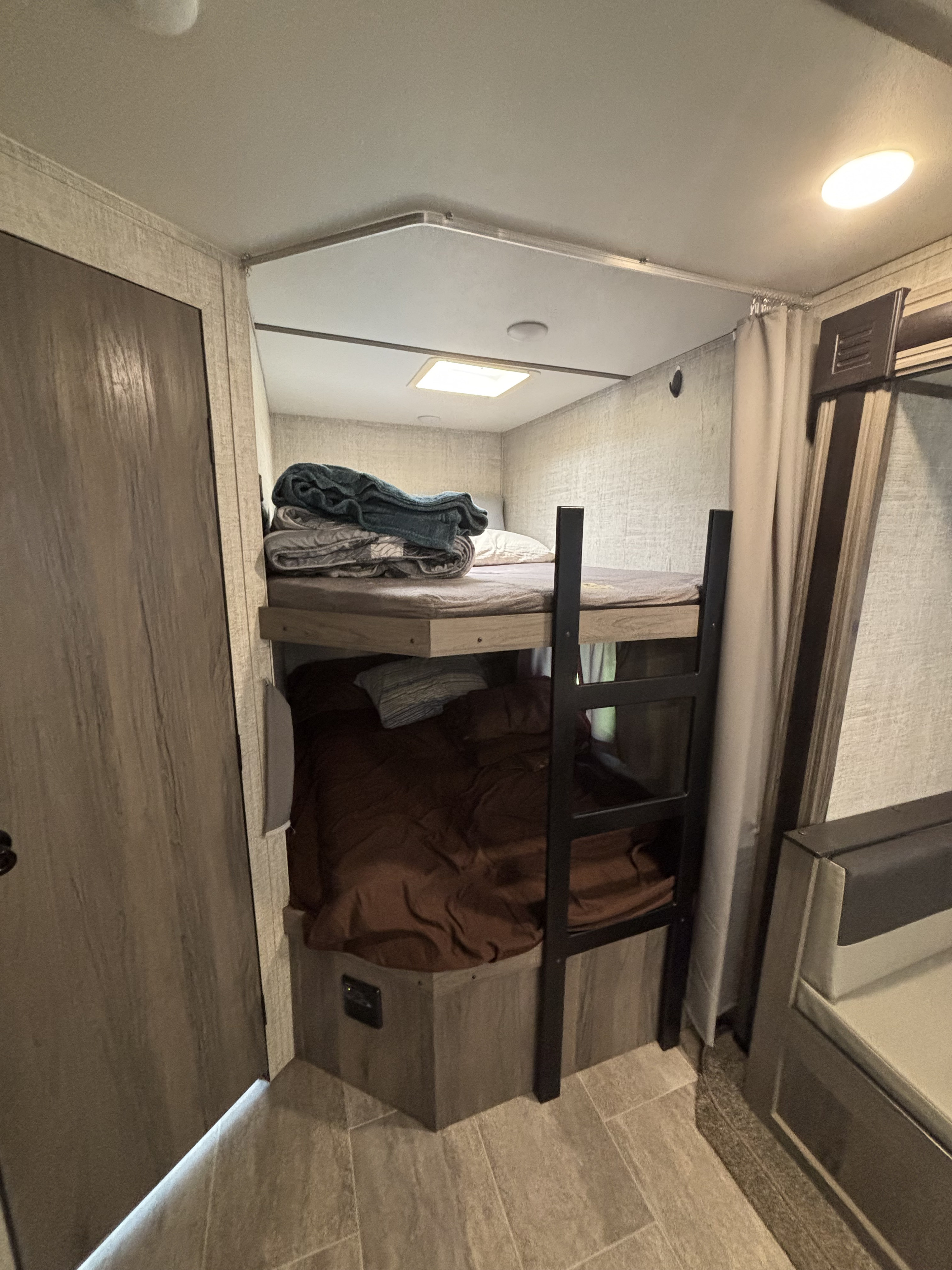 RV rental interior features a bunk bed setup for extra sleeping capacity, with privacy curtains and modern finishes.. Gulf Stream Ameri-Lite 2021