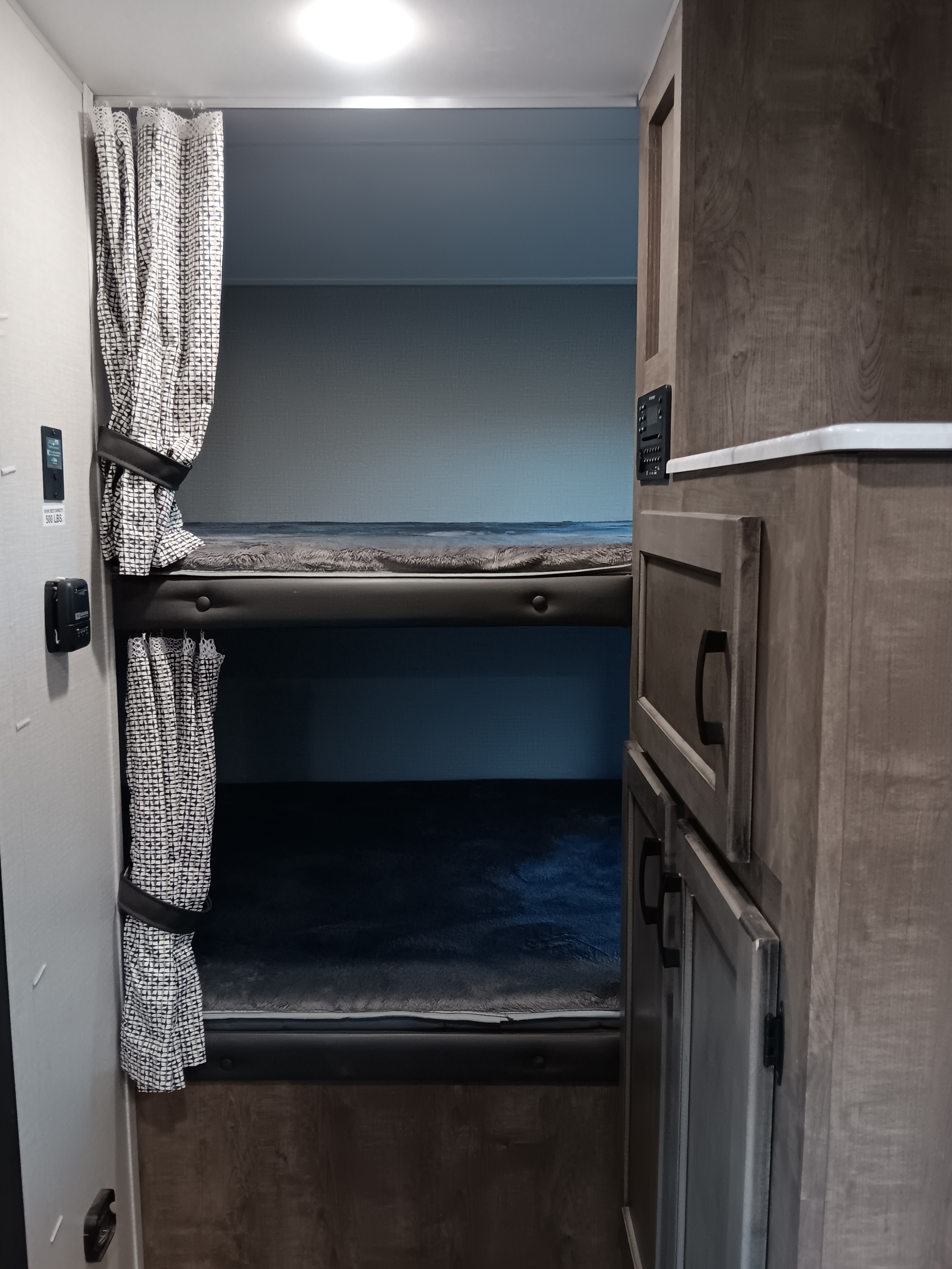 RV rental bunk beds with privacy curtains & cabinetry, showing a compact, organized sleeping area.. Sonic Sonic Trailer 2021