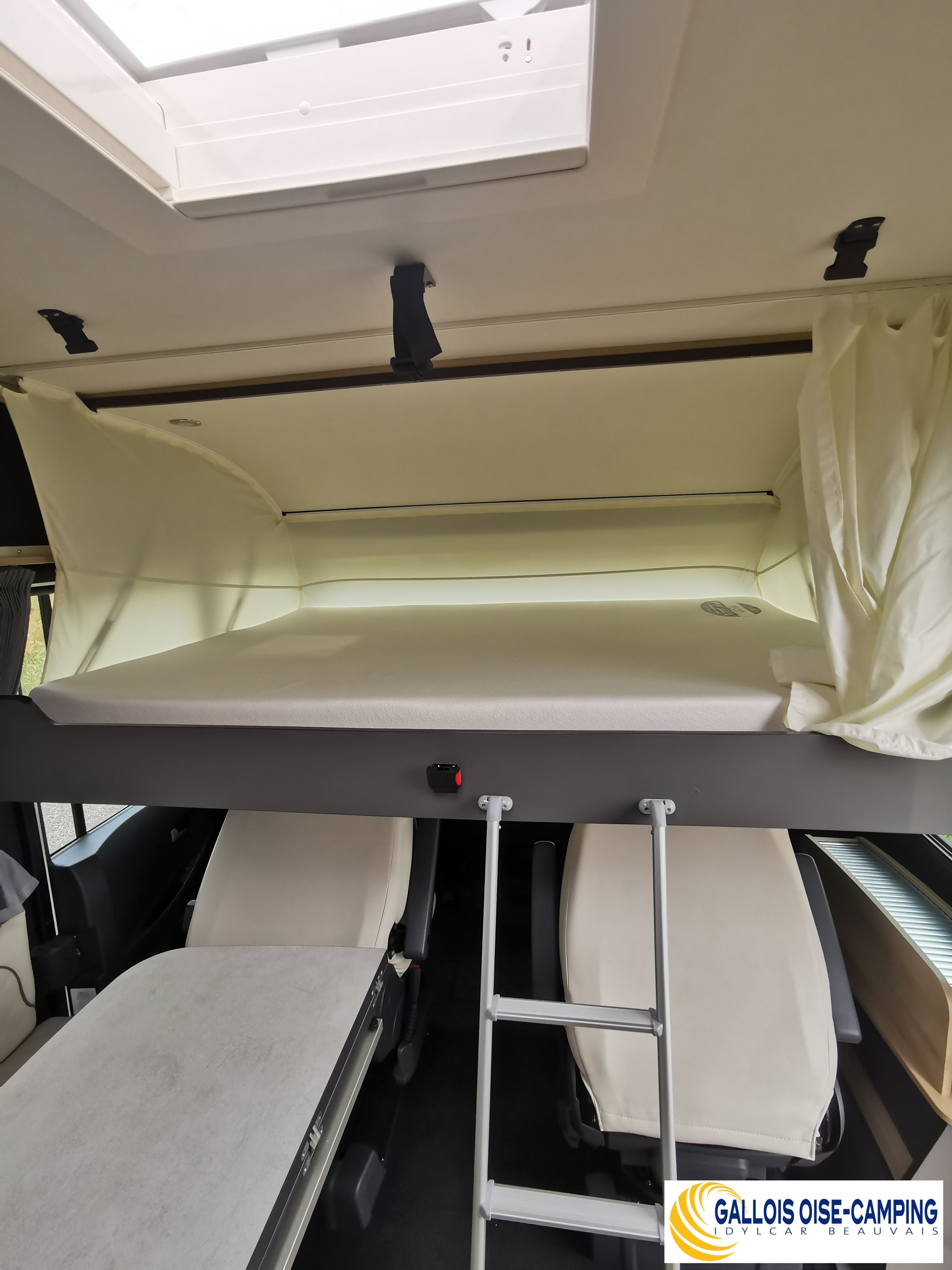 RV rental interior features a bunk bed, access ladder, and passenger seats below a skylight, ideal for camping adventures.. ITINEO CJ660 2023
