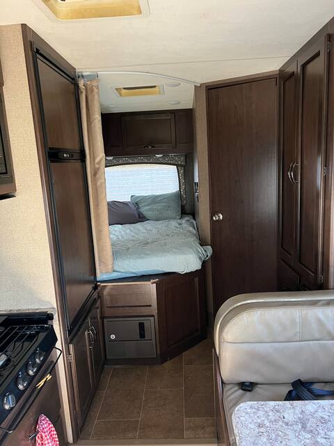 Experience the comfort of this RV rental. Interior shows a bed, kitchen counter with stove, fridge, and dinette.. Other Chateau 2018