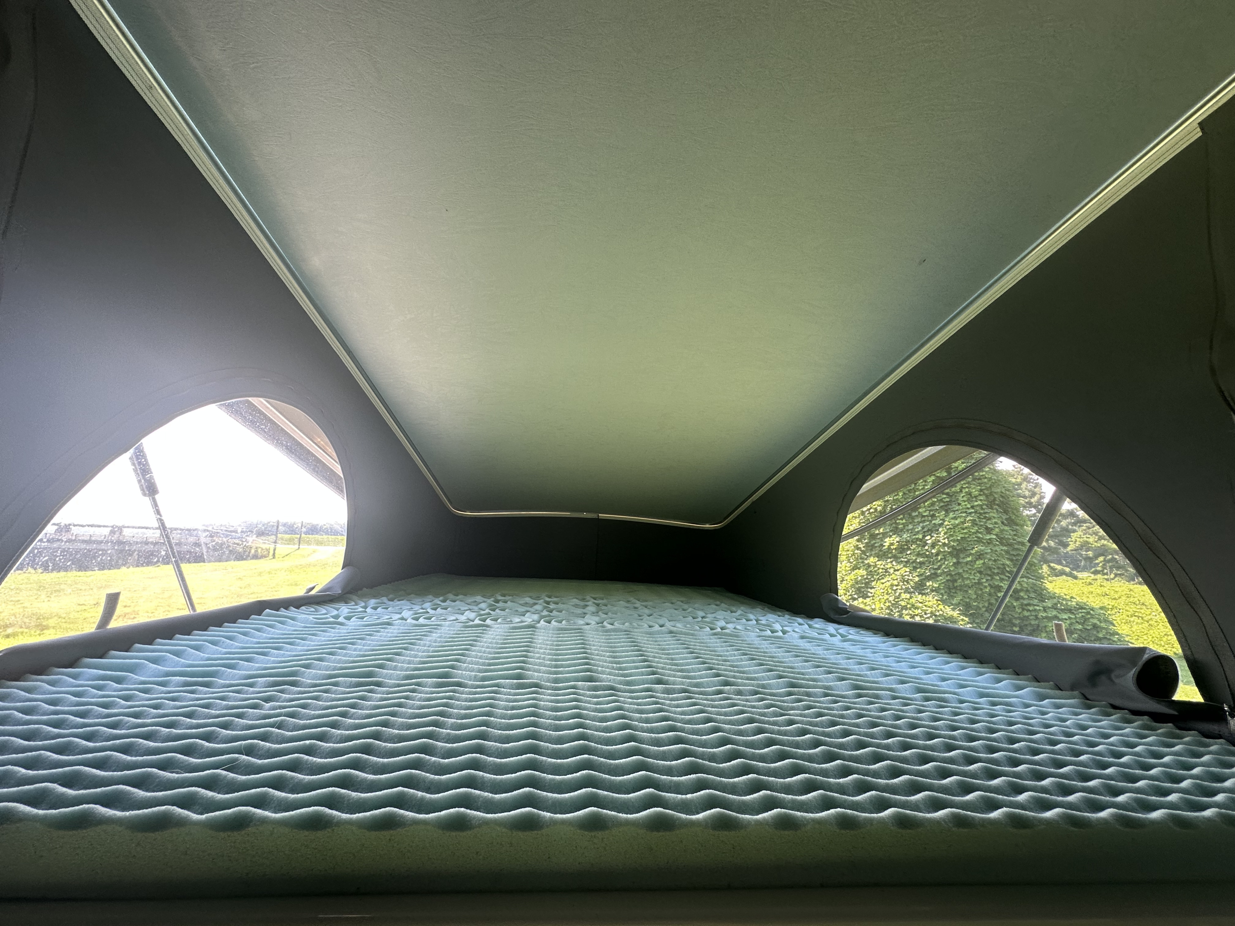 Cozy RV rental pop-top bed features an egg-crate mattress, offering scenic views for your travels.. Winnebago Solis 2023