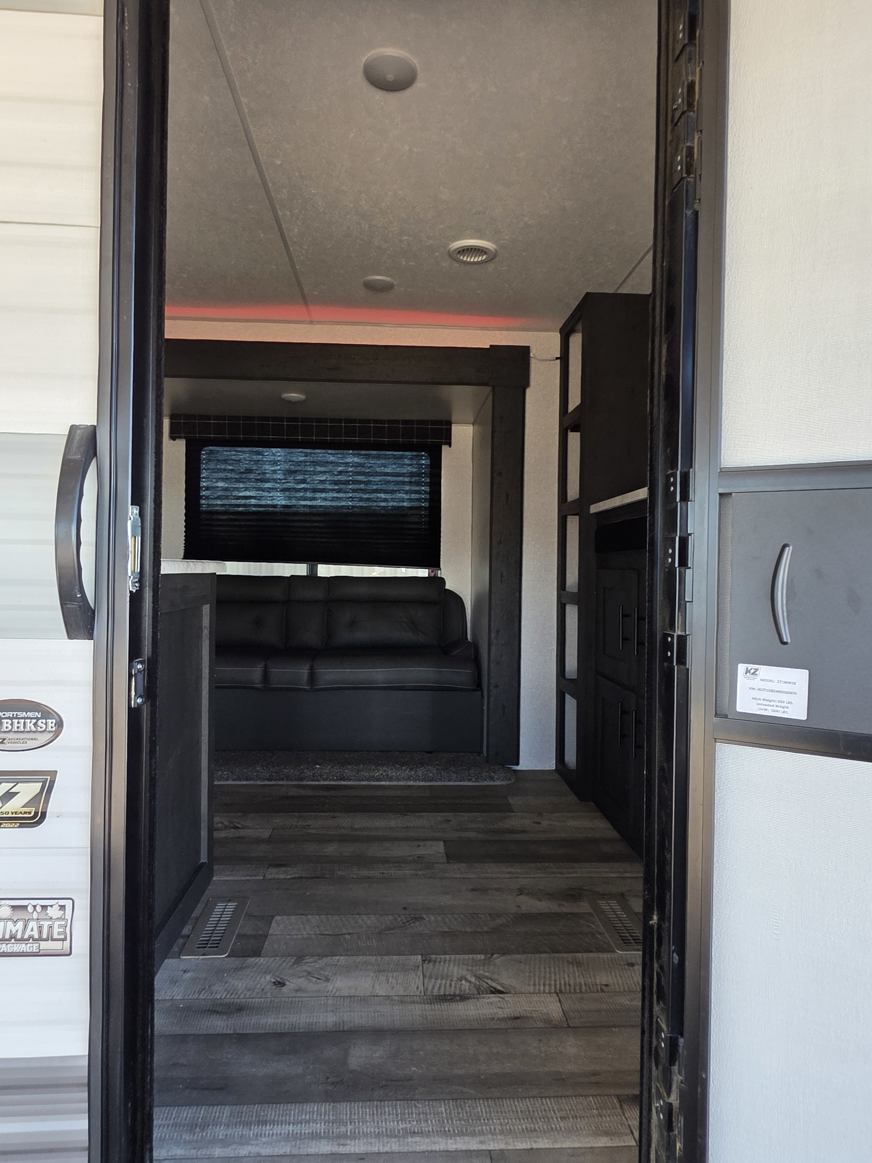 Step inside this modern rv rental. View of sofa, bunk area, and stylish interior from the open doorway.. KZ 271BHKSE 2022