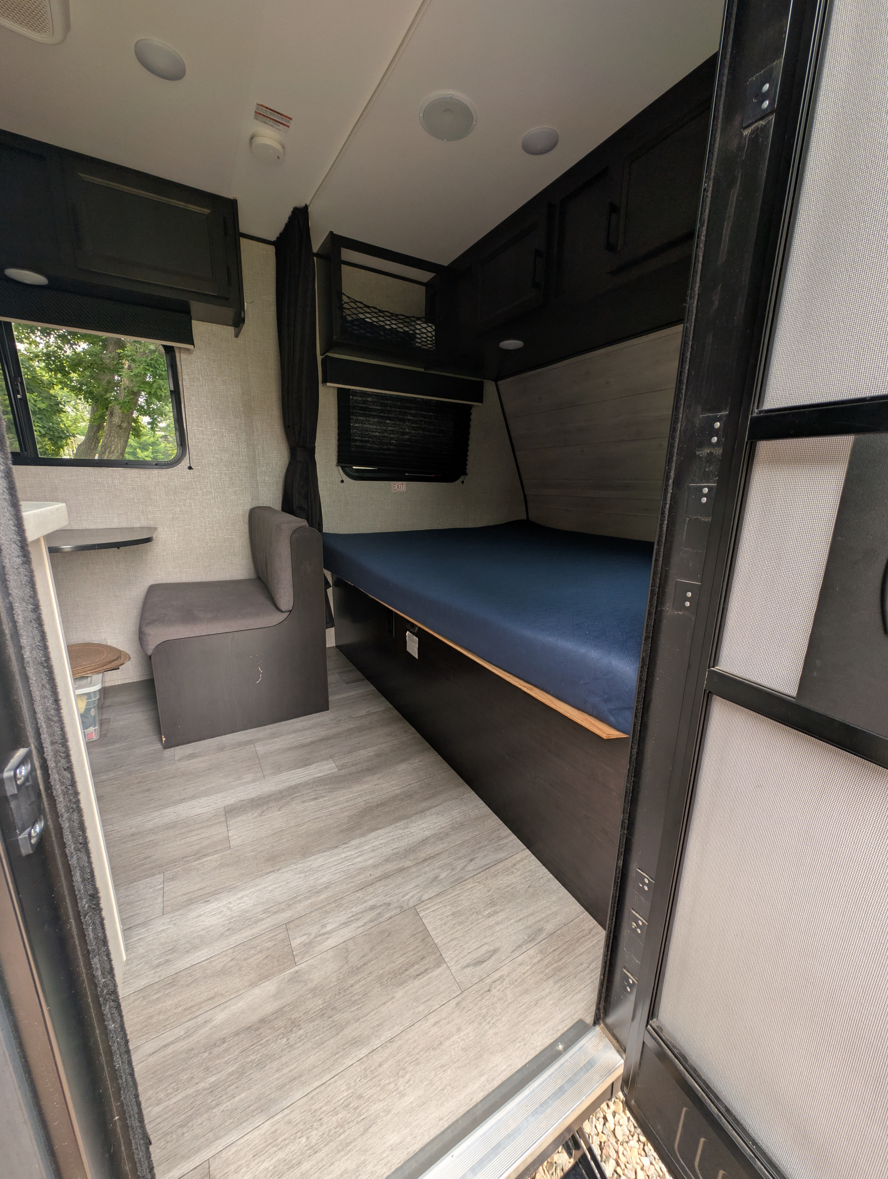 Inside an rv rental: a cozy dinette, a large bed, and modern wood flooring for a comfortable stay.. Jayco Jay Flight SLX 2022