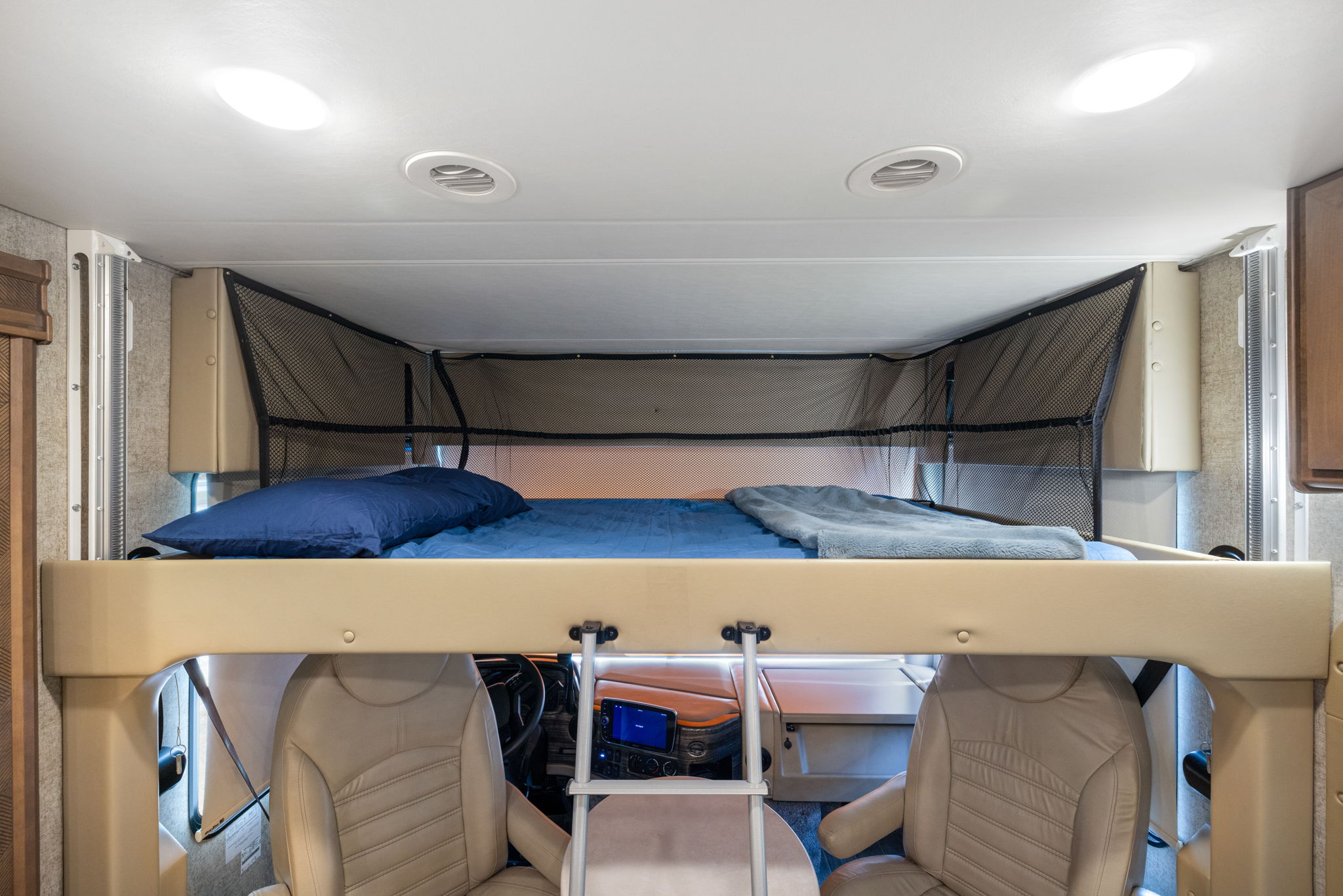 This RV rental offers a cozy overhead bunk bed with a safety net, located above the front cab for comfortable travel.. Thor Miramar 2021