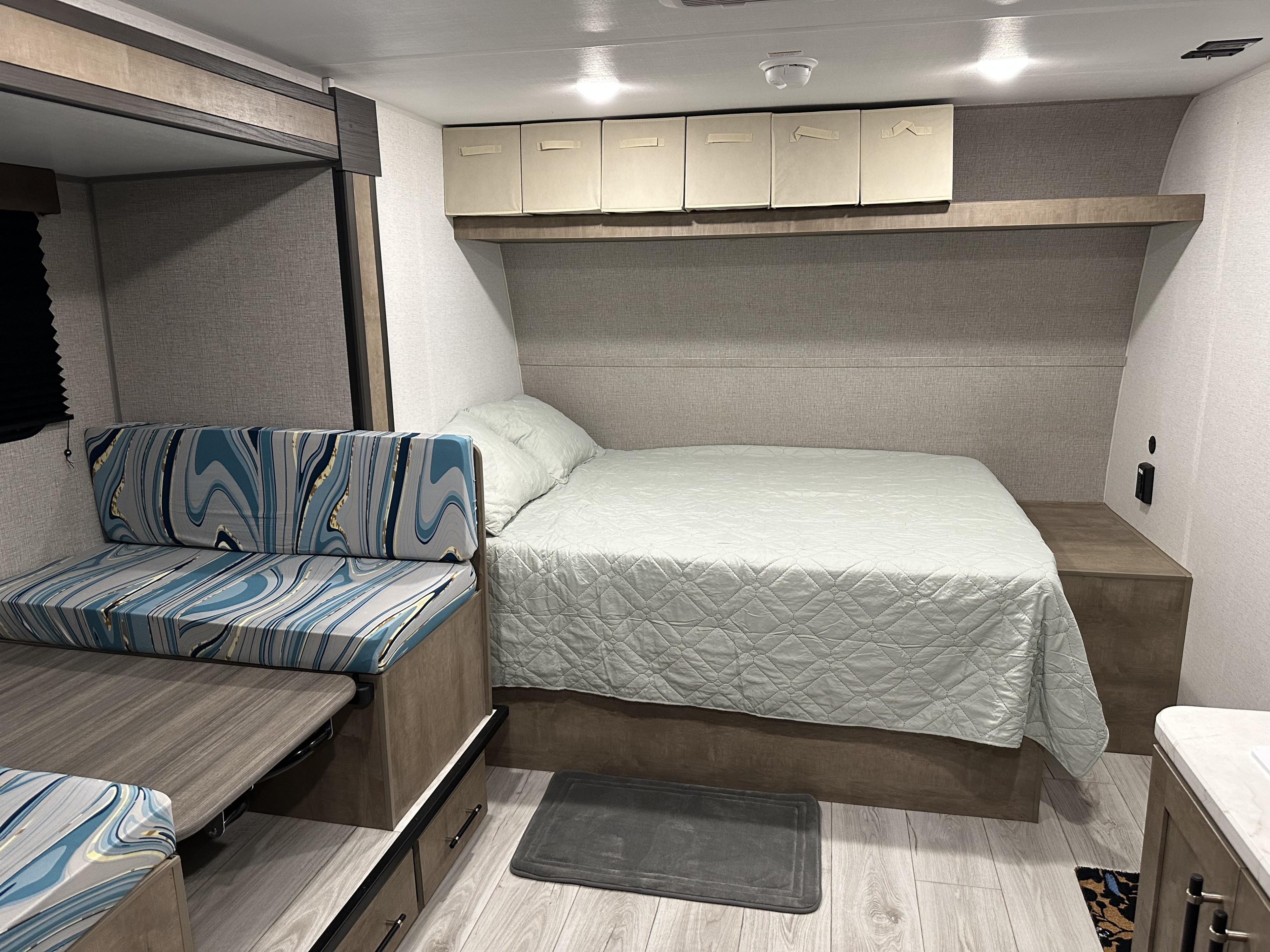 Modern RV rental interior with a comfy bed, versatile dinette seating, and practical overhead storage.. Keystone RV Springdale 2025
