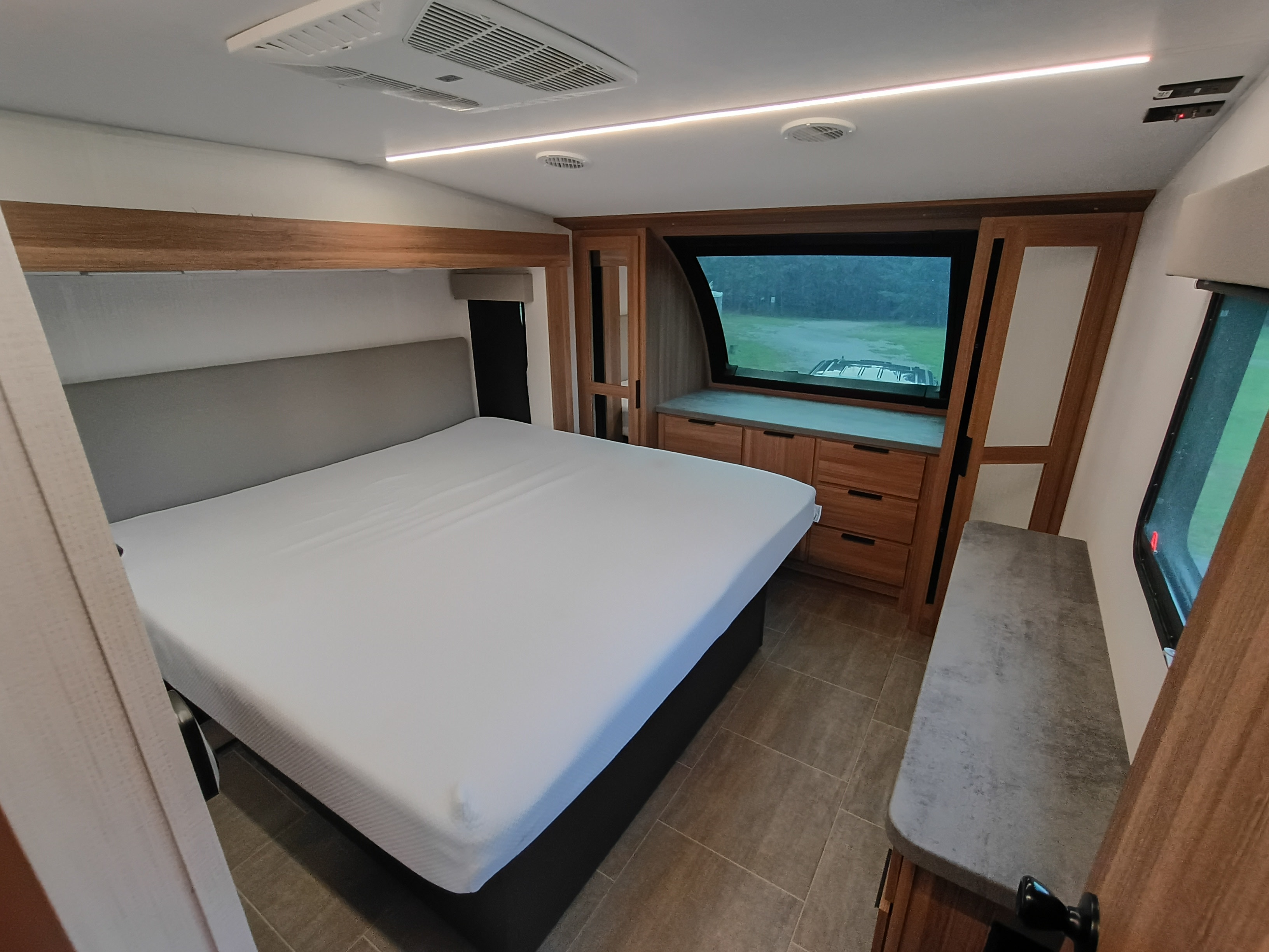 Explore in comfort with this RV rental bedroom! Features a large bed, built-in storage, overhead AC, and scenic window.. Heartland Corterra 2025