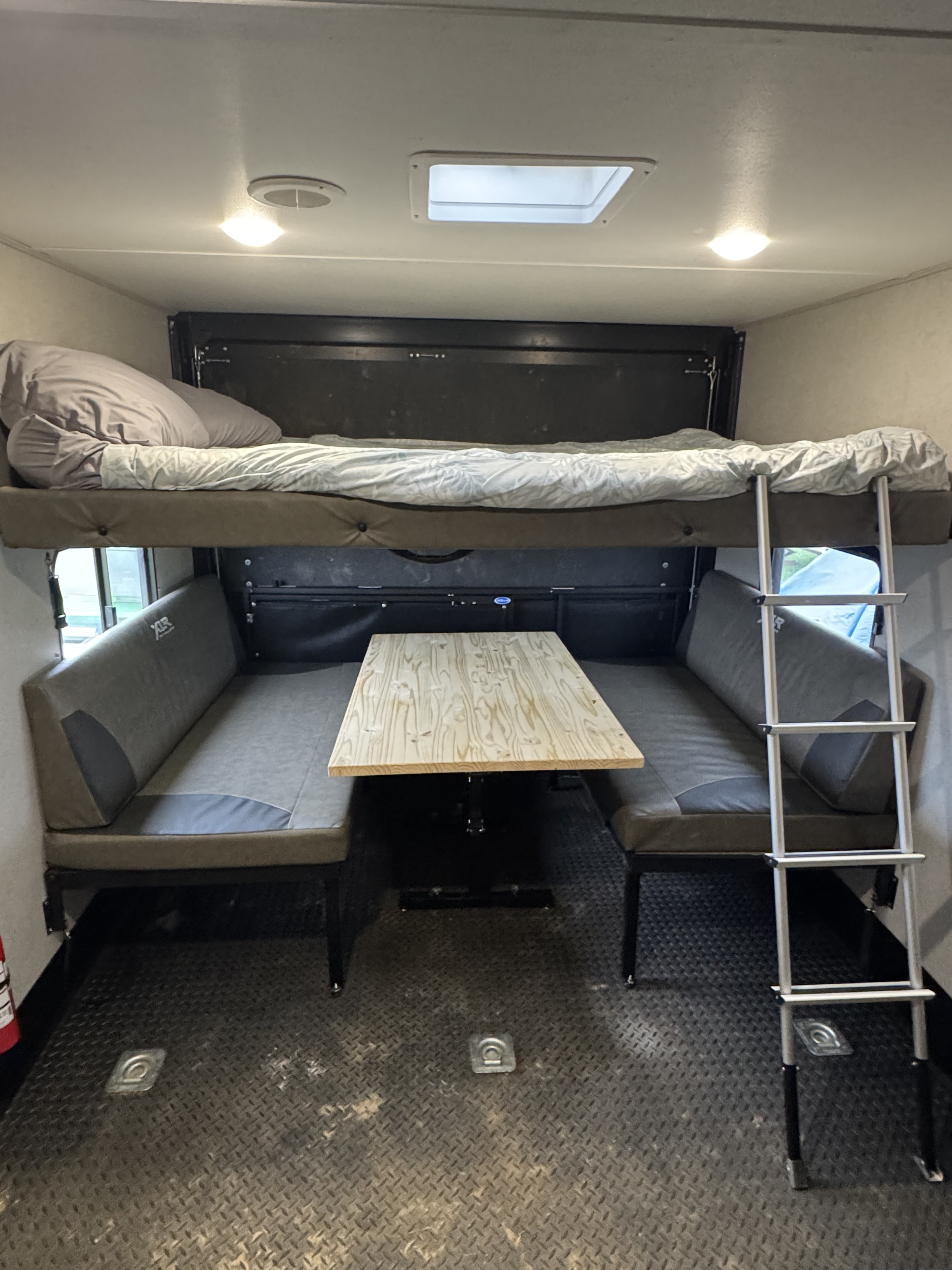 This RV rental features a versatile interior with bunk beds, a dinette table, and diamond plate flooring, ideal for travel.. Forest River XLR Micro Boost Toy Hauler 2022