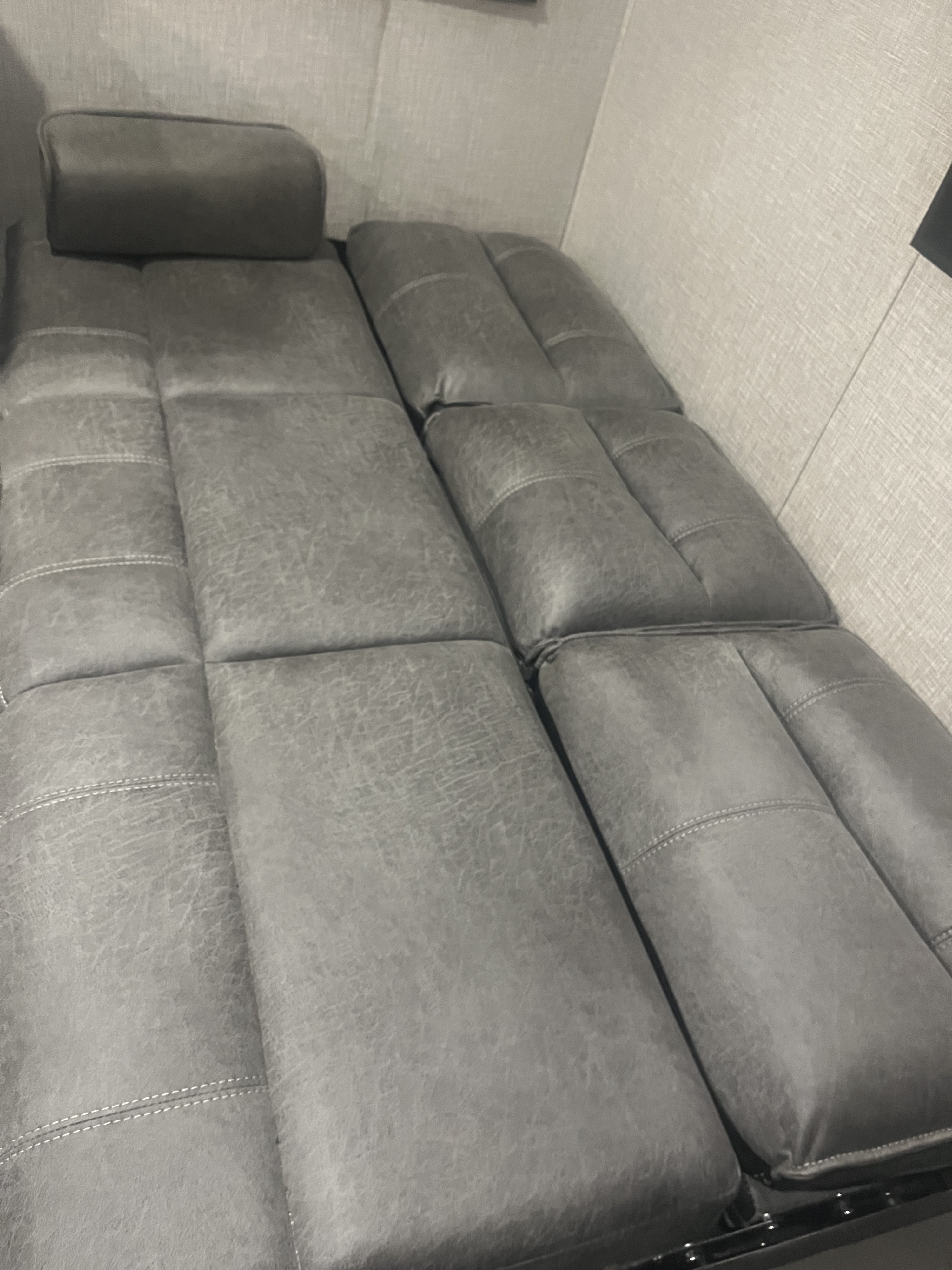 Grey segmented cushions convert to a bed, ideal for an RV rental's compact sleeping area.. Jayco Jay Flight 2023