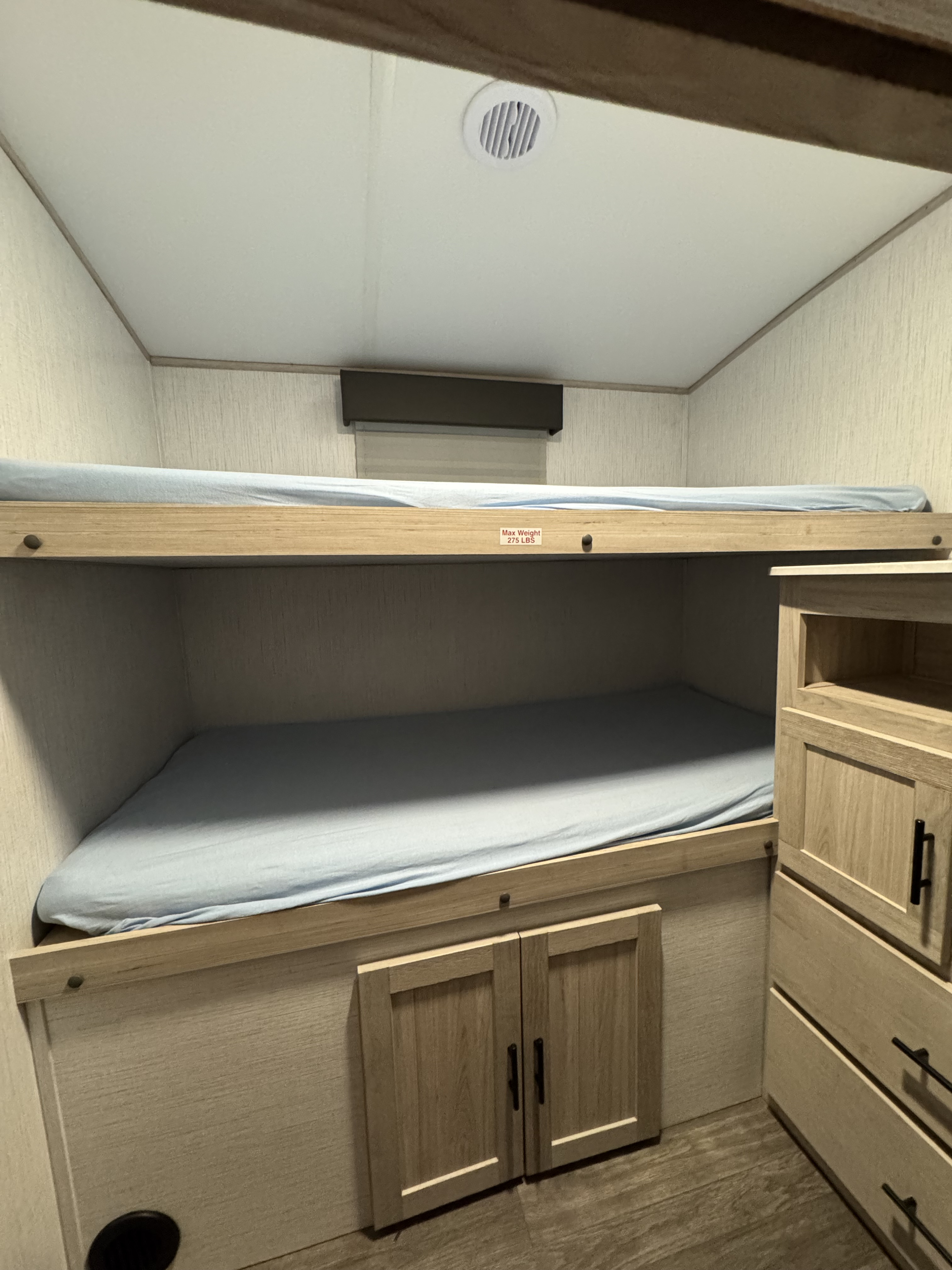 Cozy RV rental bunk area with two beds, built-in storage, and a ceiling vent.. Cruiser RV Shadow Cruiser 2022