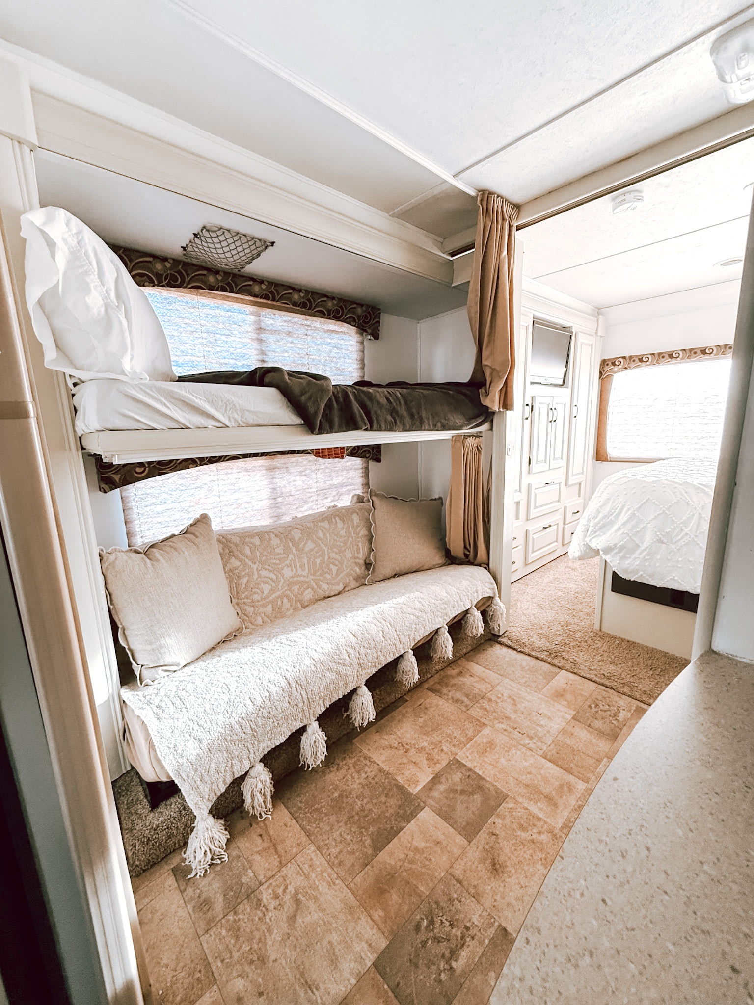 Inside a comfortable RV rental with bunk beds, a sofa, and a bright master suite. Relaxing travel space.. Forest River Sunseeker 2015