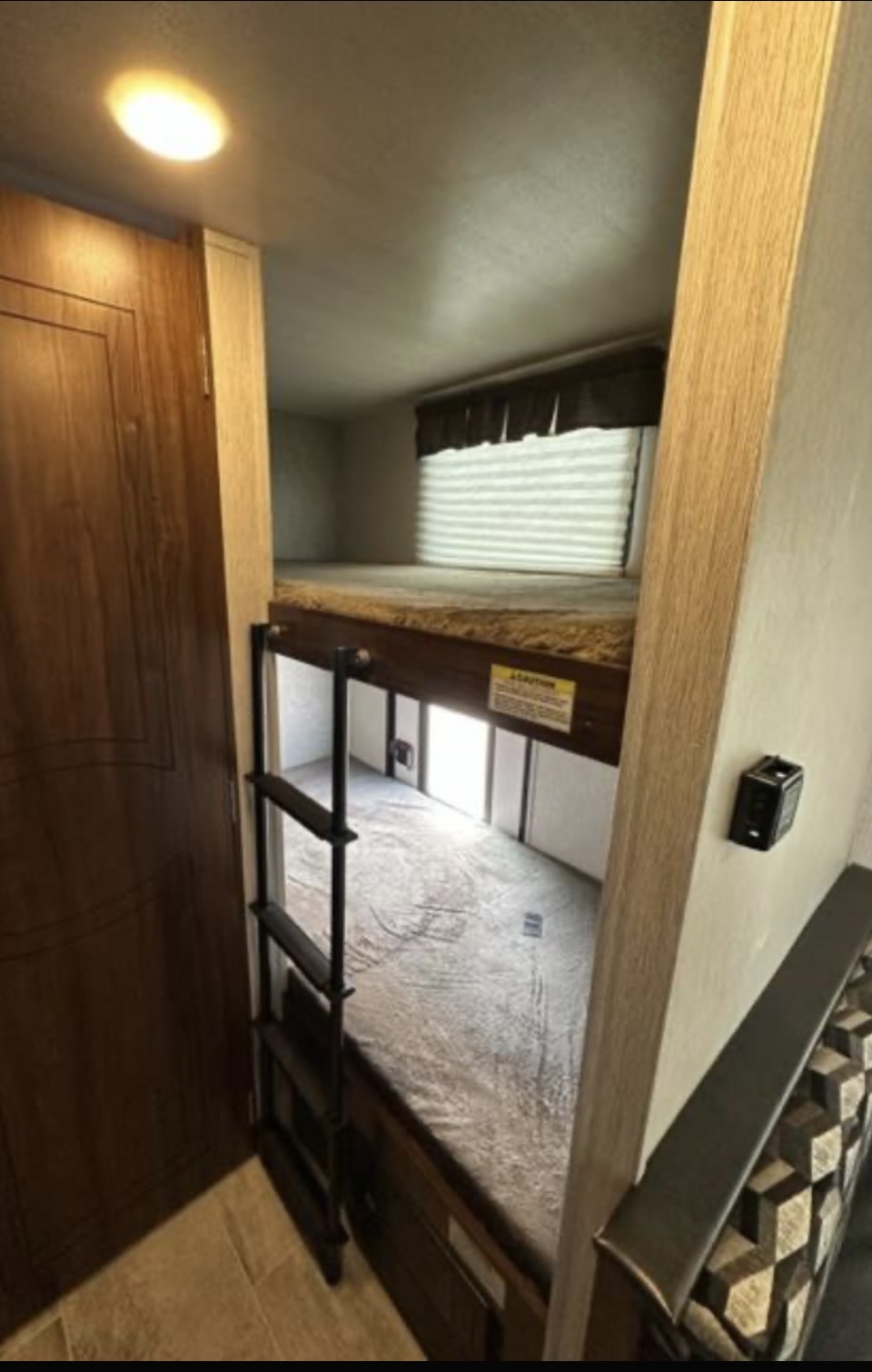 Step inside this RV rental to find comfortable bunk beds with a ladder, window, and patterned seating, ideal for families.. Mallard M185 2019