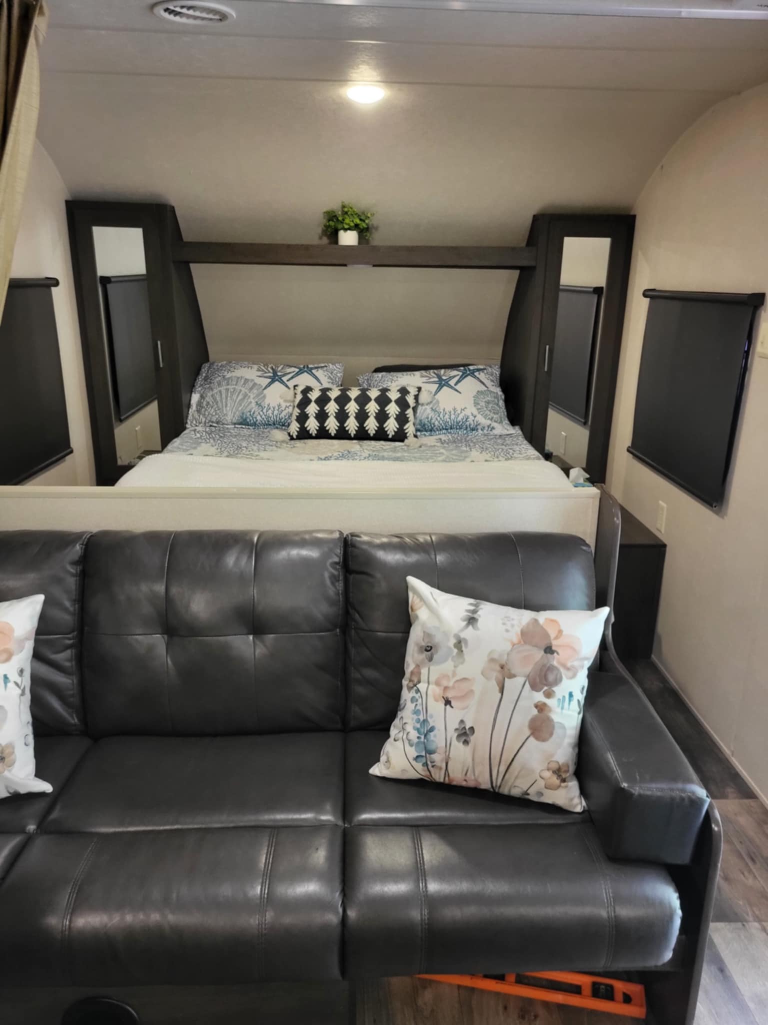 Inside a modern RV rental: a plush sofa and a built-in bed with storage. Ideal for road trip adventures.. Forest River Salem Cruise Lite 2018