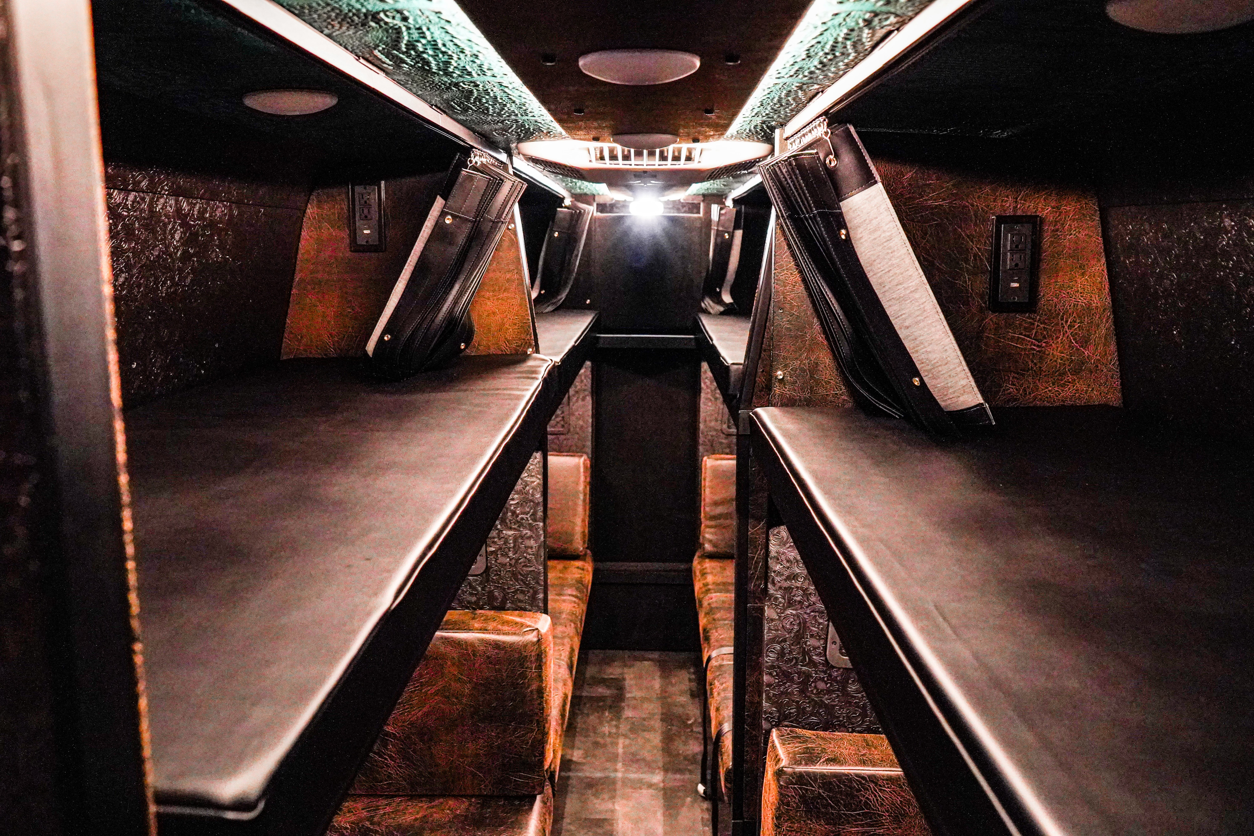 Cozy RV rental interior with multiple sleeping berths, textured walls, and charging outlets for comfort.. Bespoken Vandals Mercedes Sprinter 2024