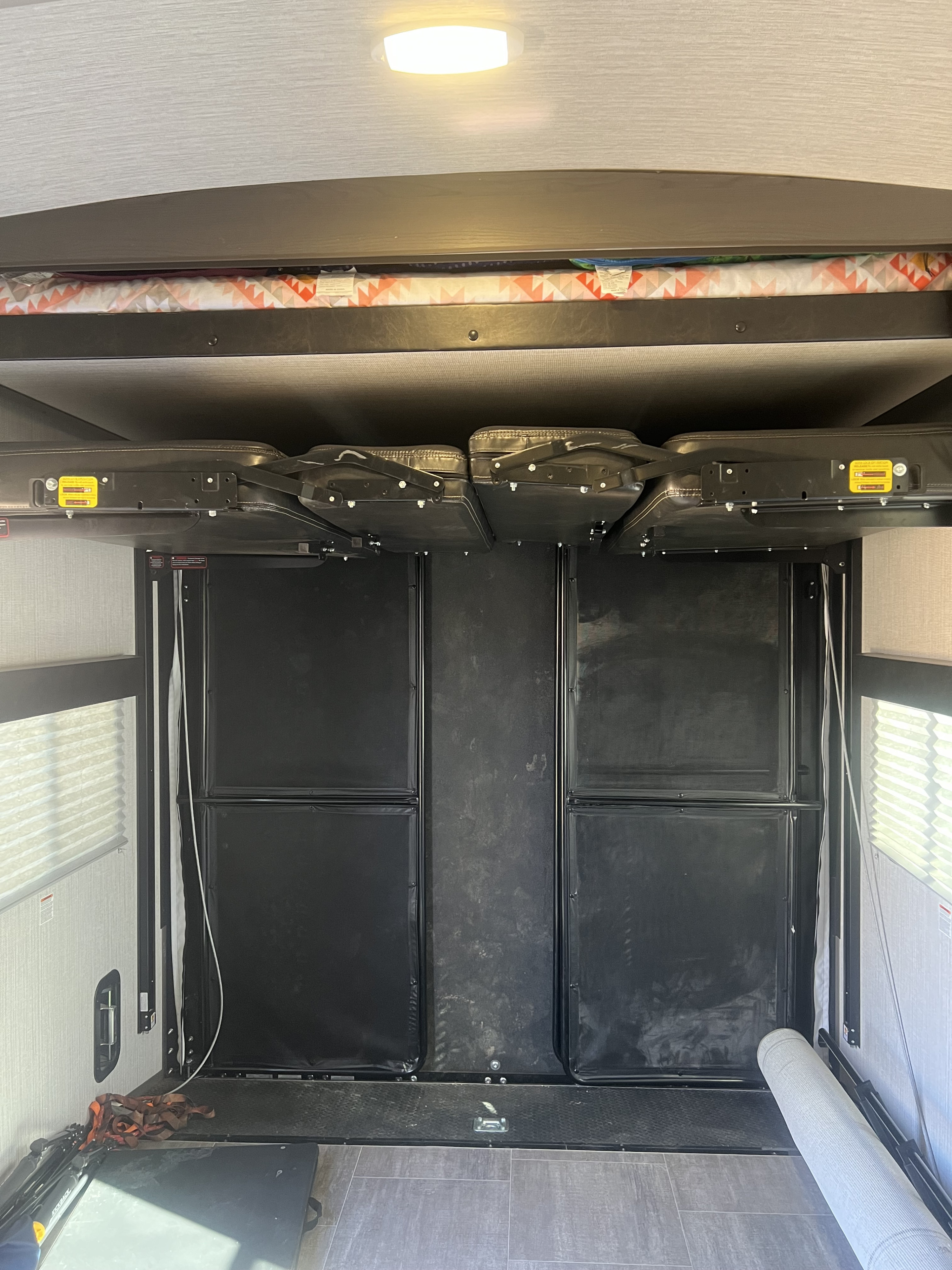 RV rental interior: versatile toy hauler garage with elevated bunk bed and folded seating, ready for adventure.. Cruiser Rv Corp Stryker 2021