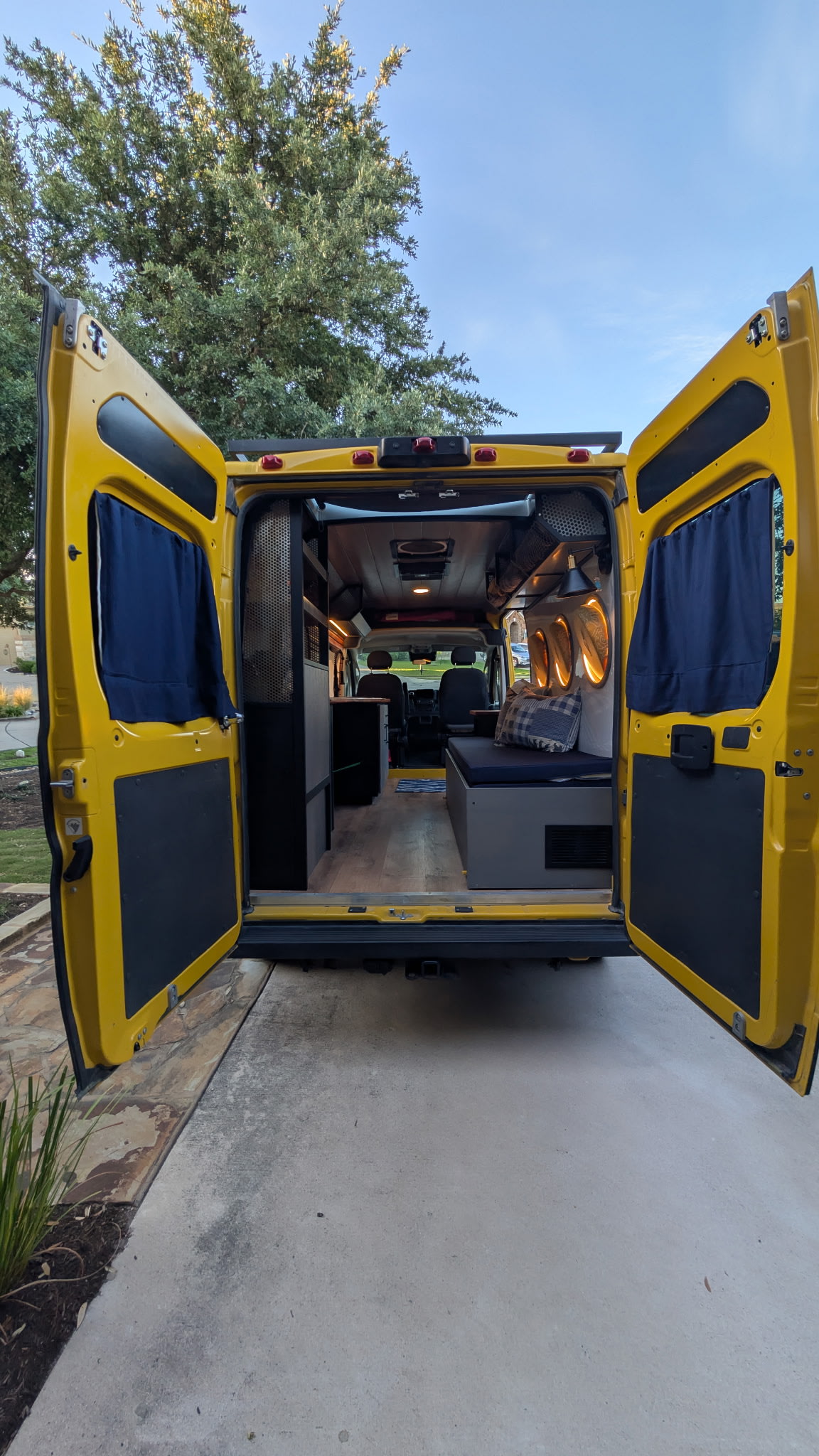 Explore this yellow camper van's spacious interior! A perfect RV rental setup with wood floors & comfy seating.. Dodge Promaster 2022