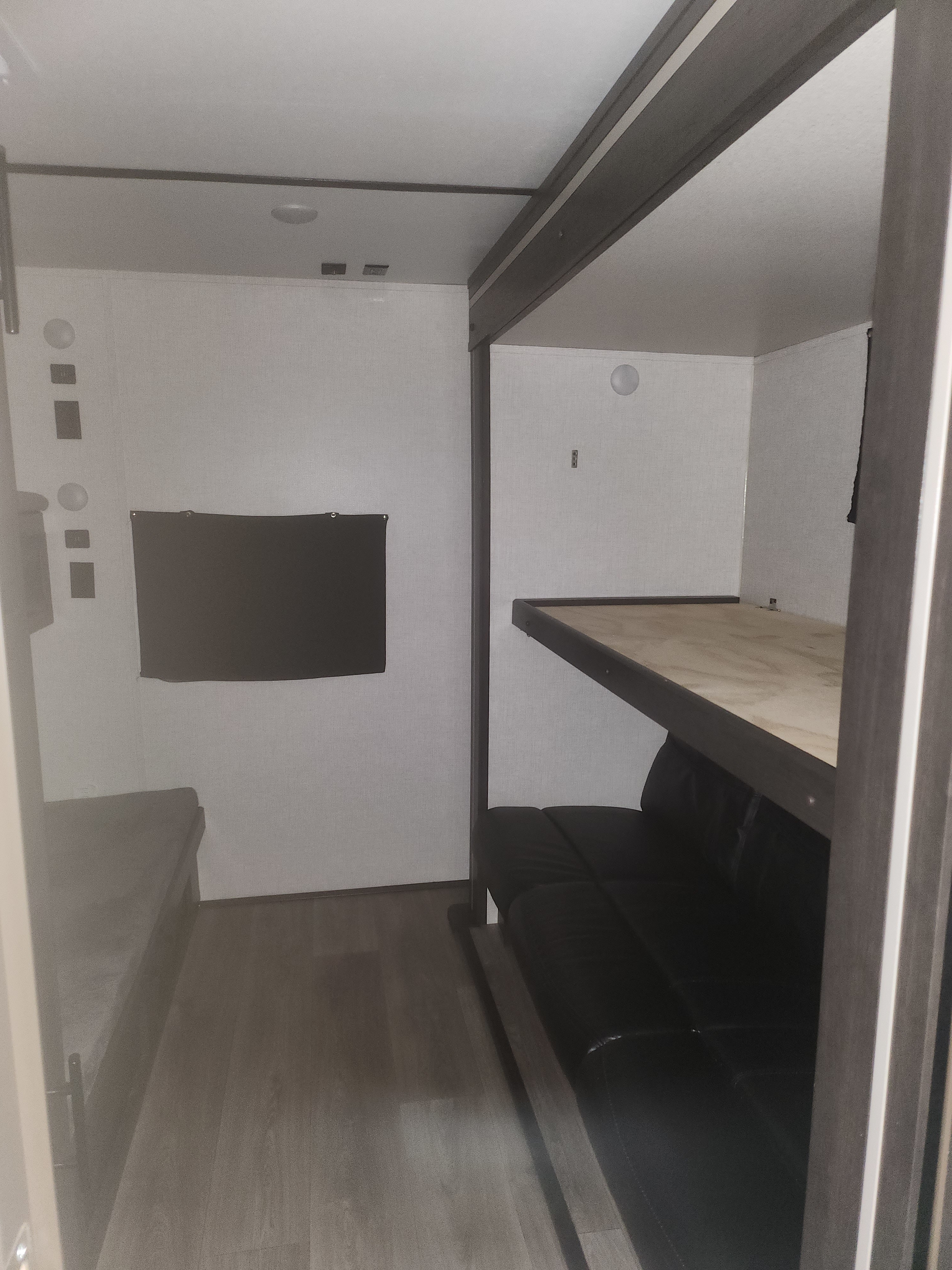 RV rental interior showing a bunk bed over a sofa and a bed on the left, optimizing compact space.. Crossroads RV Cruiser Aire 2021