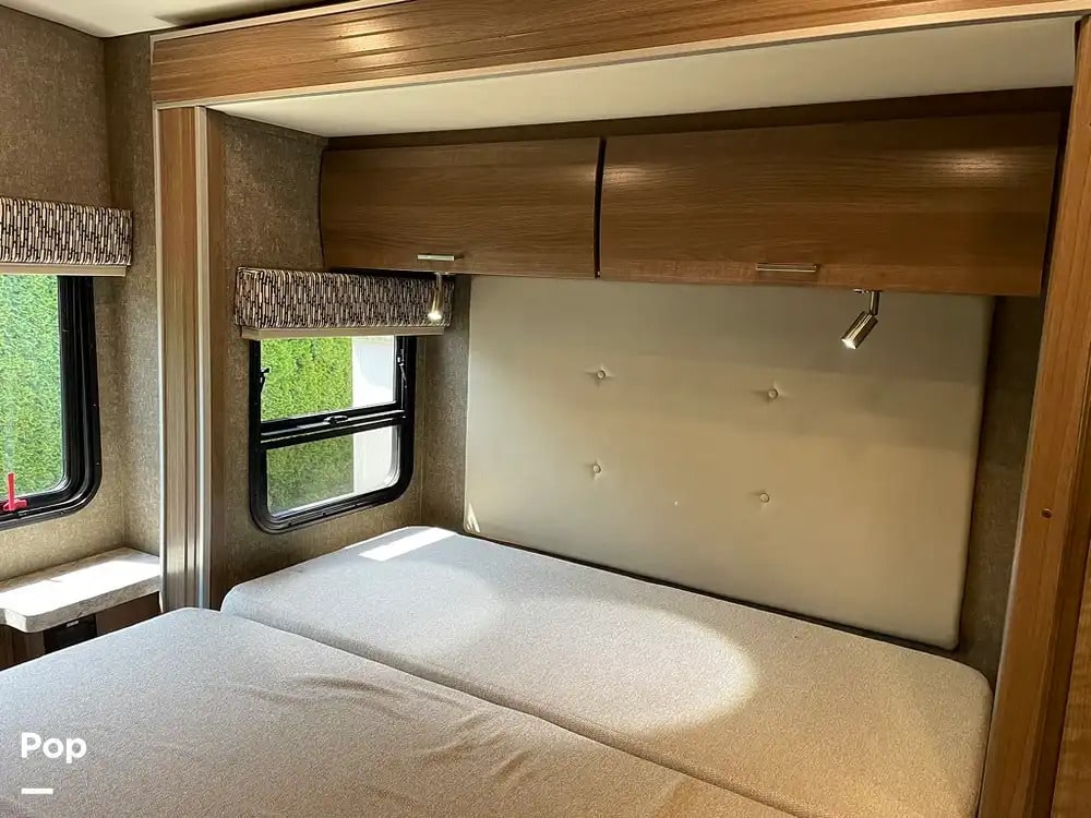 RV rental: Bright bedroom with twin beds, upholstered headboard, overhead cabinets, and windows offering a view outside.. Pulse Pulse Motorhome 2018