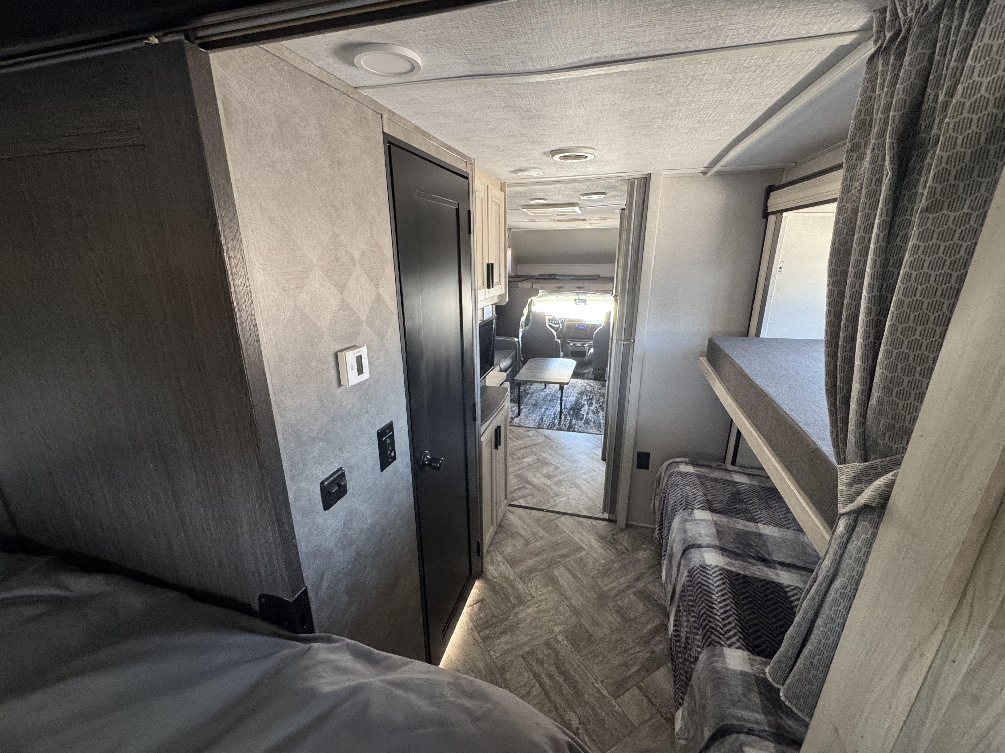 Experience an RV rental: welcoming interior hallway with bunk beds, a bathroom door, and cozy bedroom space.. Forest River Sunseeker LE 2022