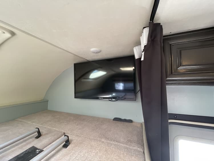 RV rental interior: A cozy bunk bed area with a mounted TV provides comfort and entertainment in this compact space.. Thor Quantum 2018
