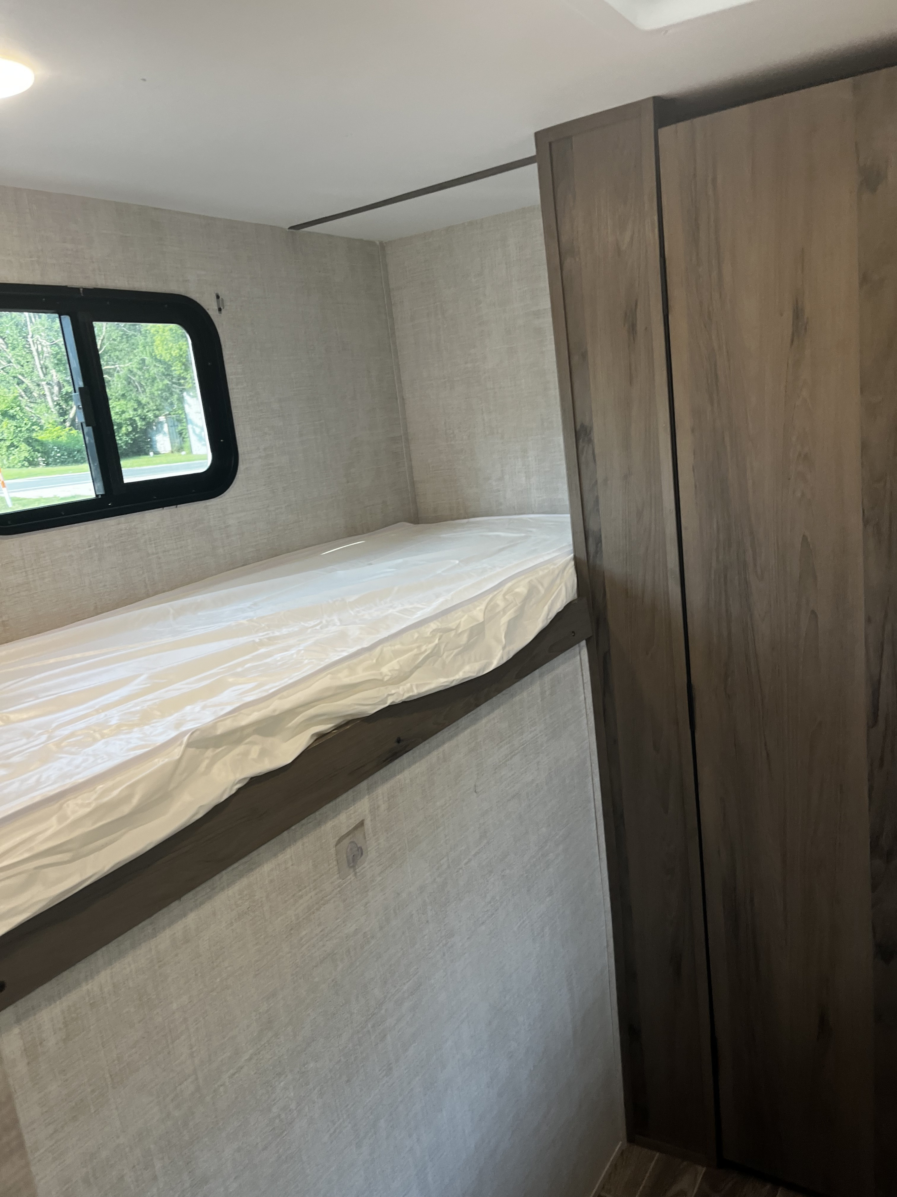 RV rental: Compact interior with a bunk bed, side window, and tall wooden storage cabinet. Ready for your adventure.. Gulf Stream Innsbruck 2022