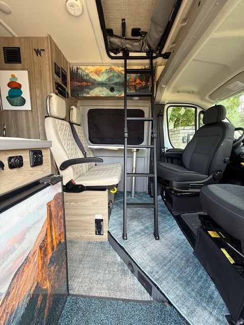 Dinette area with ladder to the pop-top area with a double bed. The table swivels out of the way to accommodate the ladder. . Winnebago Solis 59PX 2025