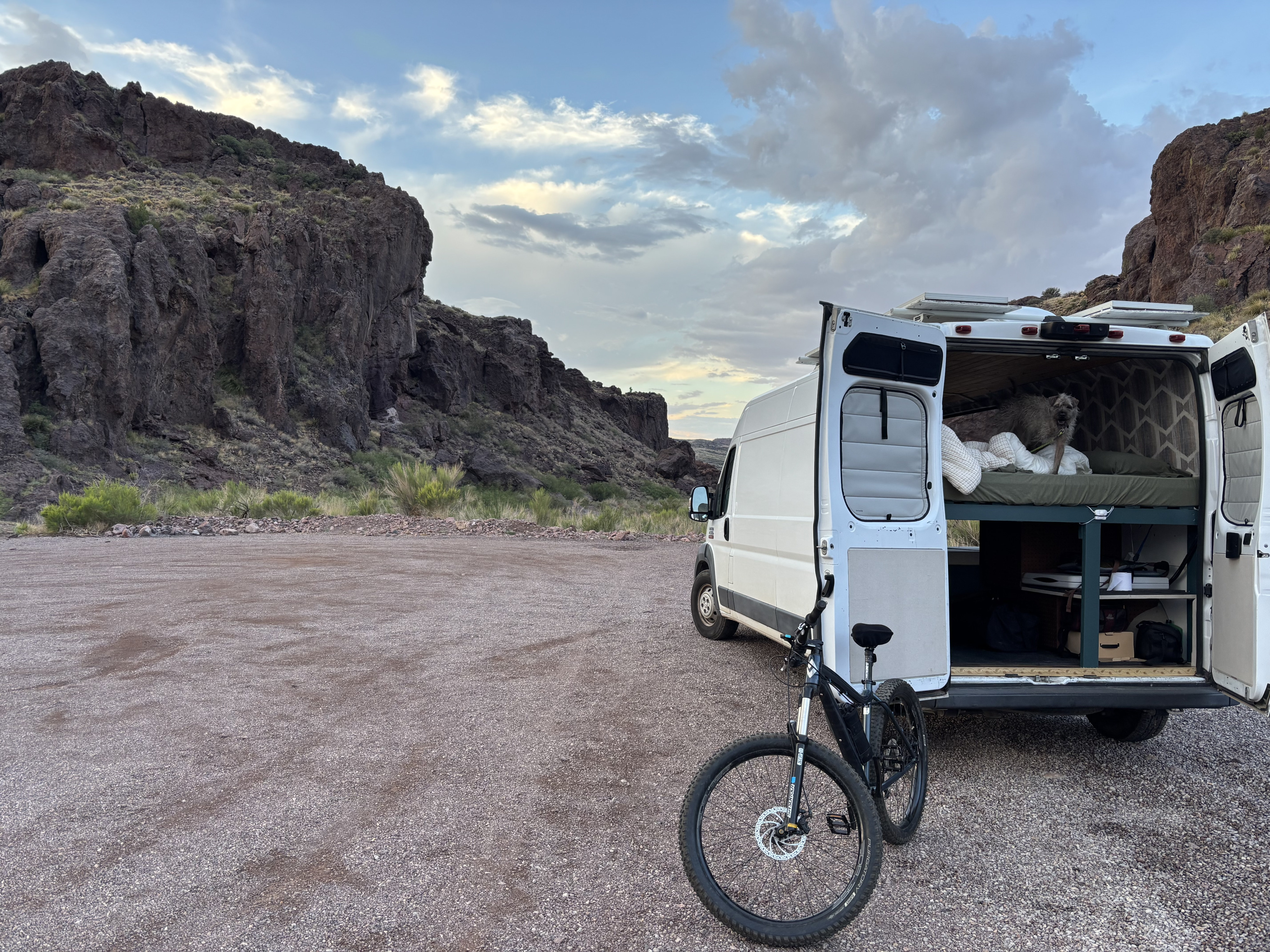 Adventure-ready RV rental setup with a dog, bike, and mountain views. Perfect for nature travel!. RAM Promaster 2500 2018