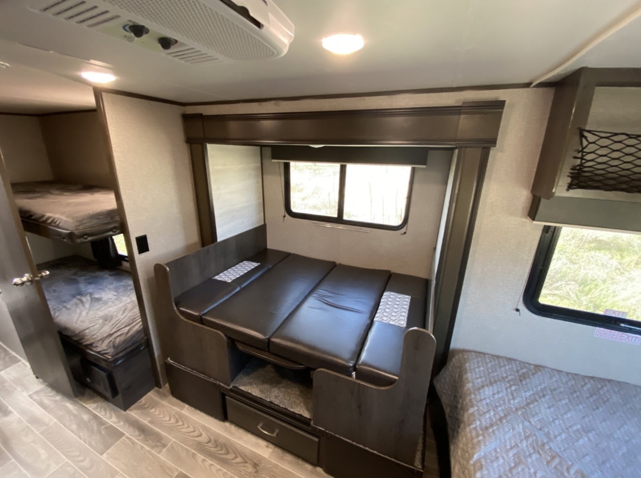 Experience this versatile RV rental interior featuring bunk beds and a converted dinette bed, maximizing sleeping space for your adventures.. Jayco Jay Flight SLX Baja Edition 2021