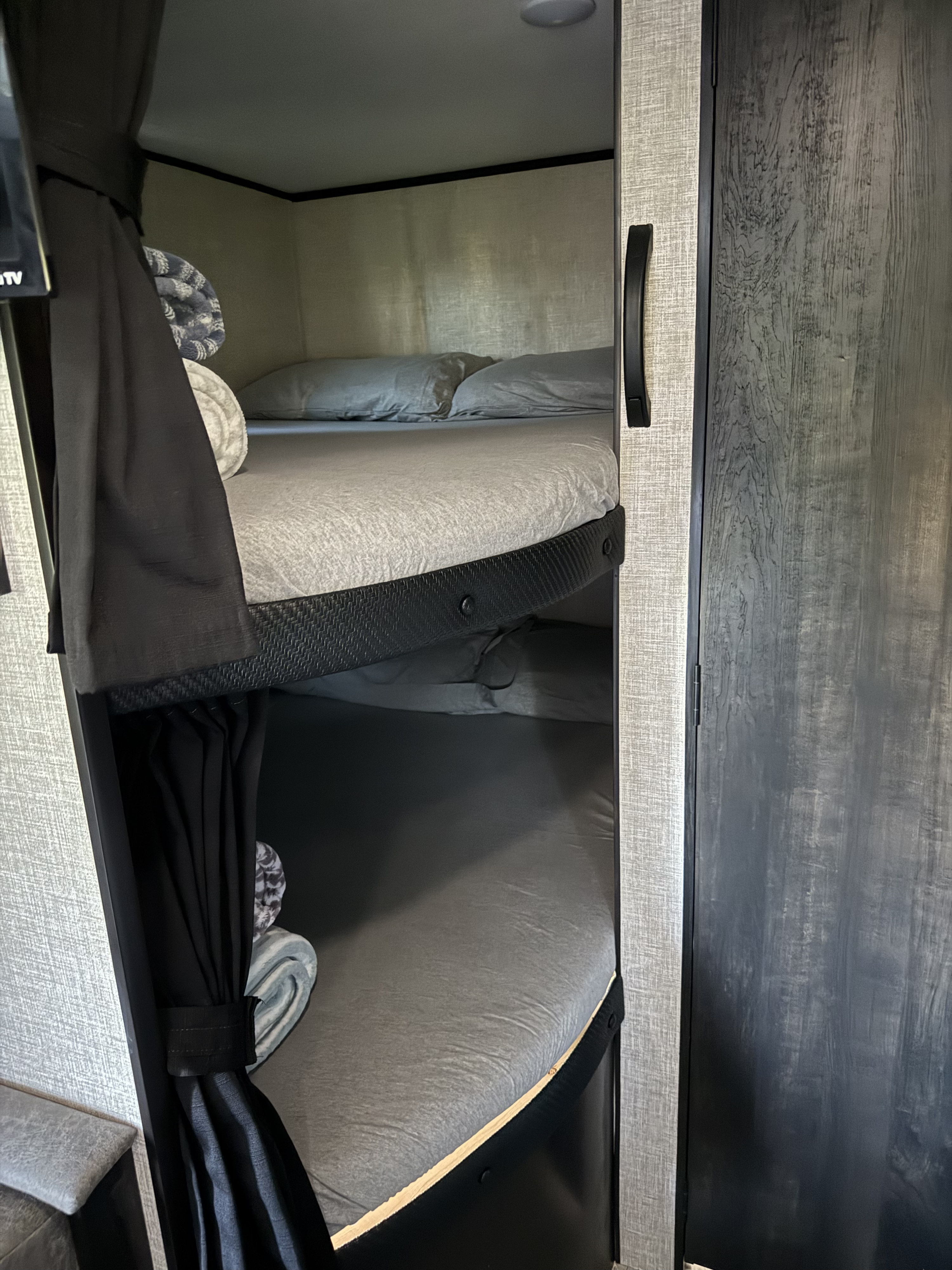 RV rental: Interior shows two cozy bunk beds with grey bedding & black privacy curtains, ideal sleeping space in a camper.. Jayco Jay Flight SLX 2022
