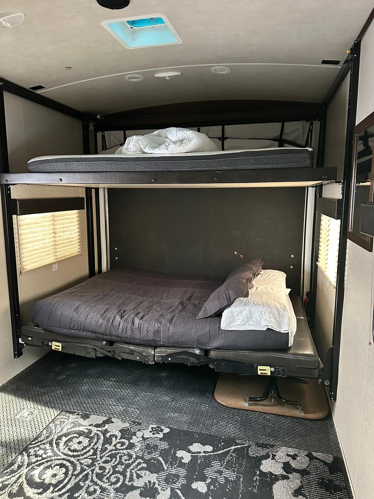 This RV rental features a toy hauler interior with power bunk beds, a convertible lower bed, and durable flooring.. Heartland Torque 2018