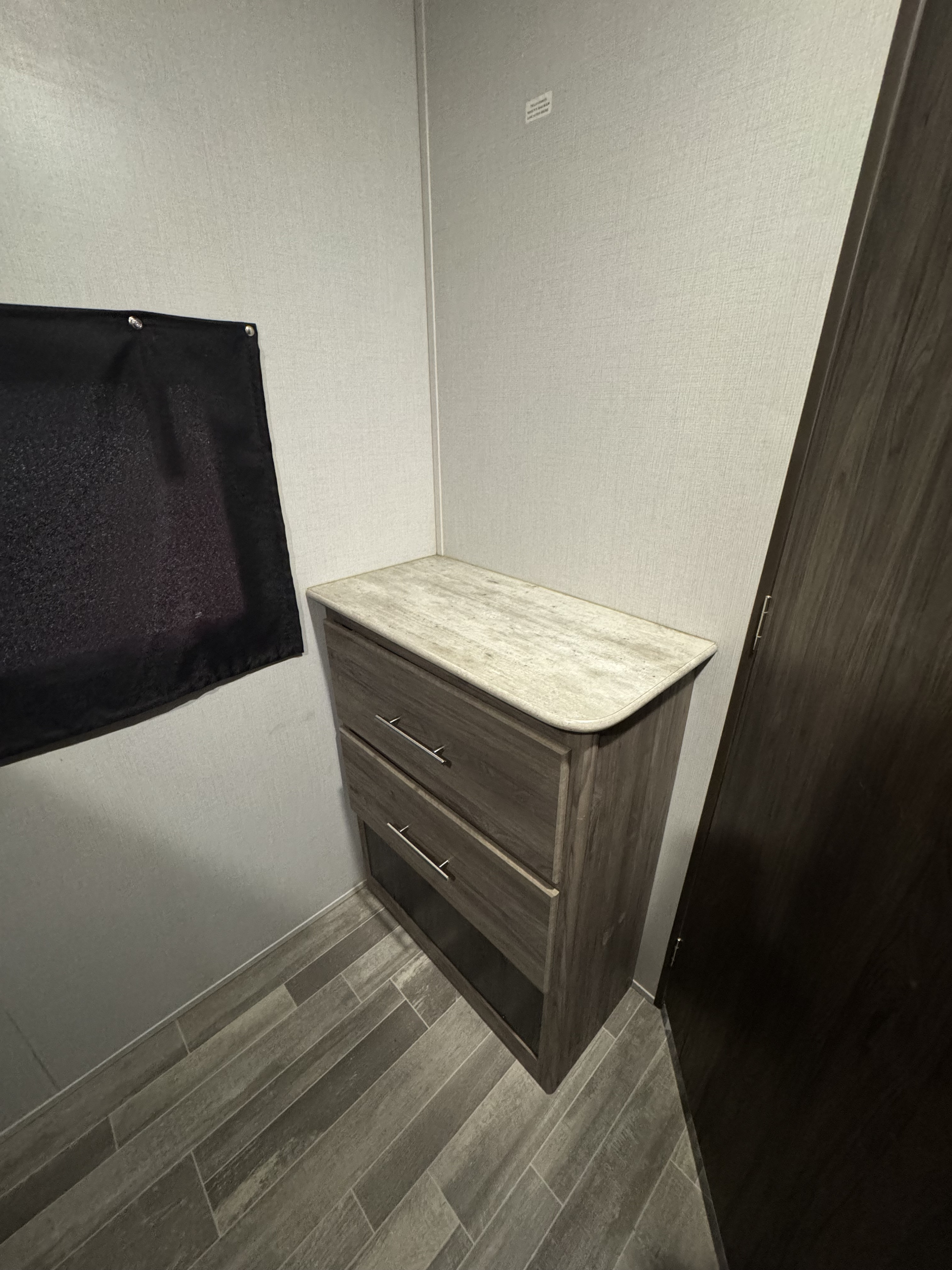 Compact RV rental interior featuring a wood dresser with drawers, light top, and wood-look floor. Efficient storage.. Crossroads RV Zinger 2020