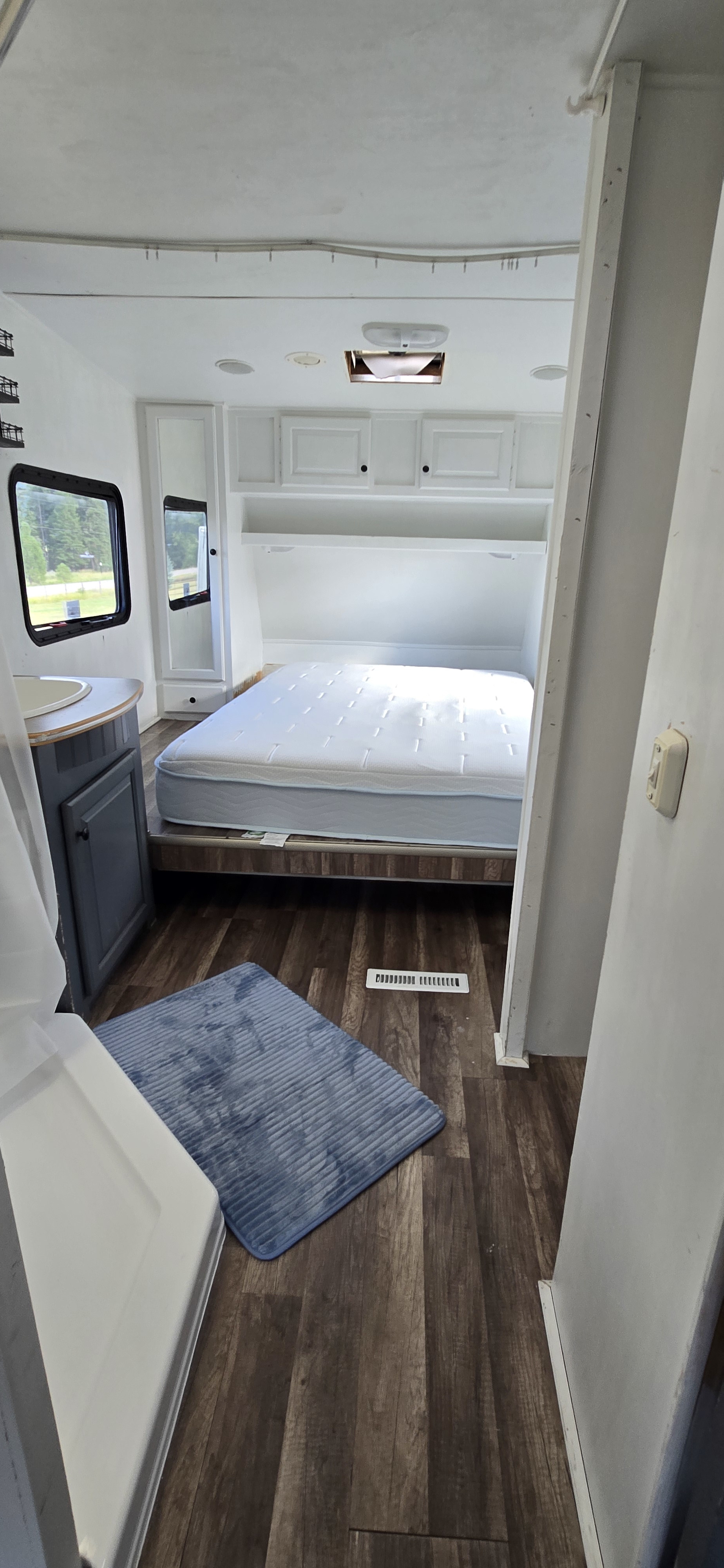 Spacious RV rental bedroom with a comfy mattress, white cabinets, and wood-look flooring. Perfect for your travels.. R-Vision Trail-Lite Trail-Bay 2005