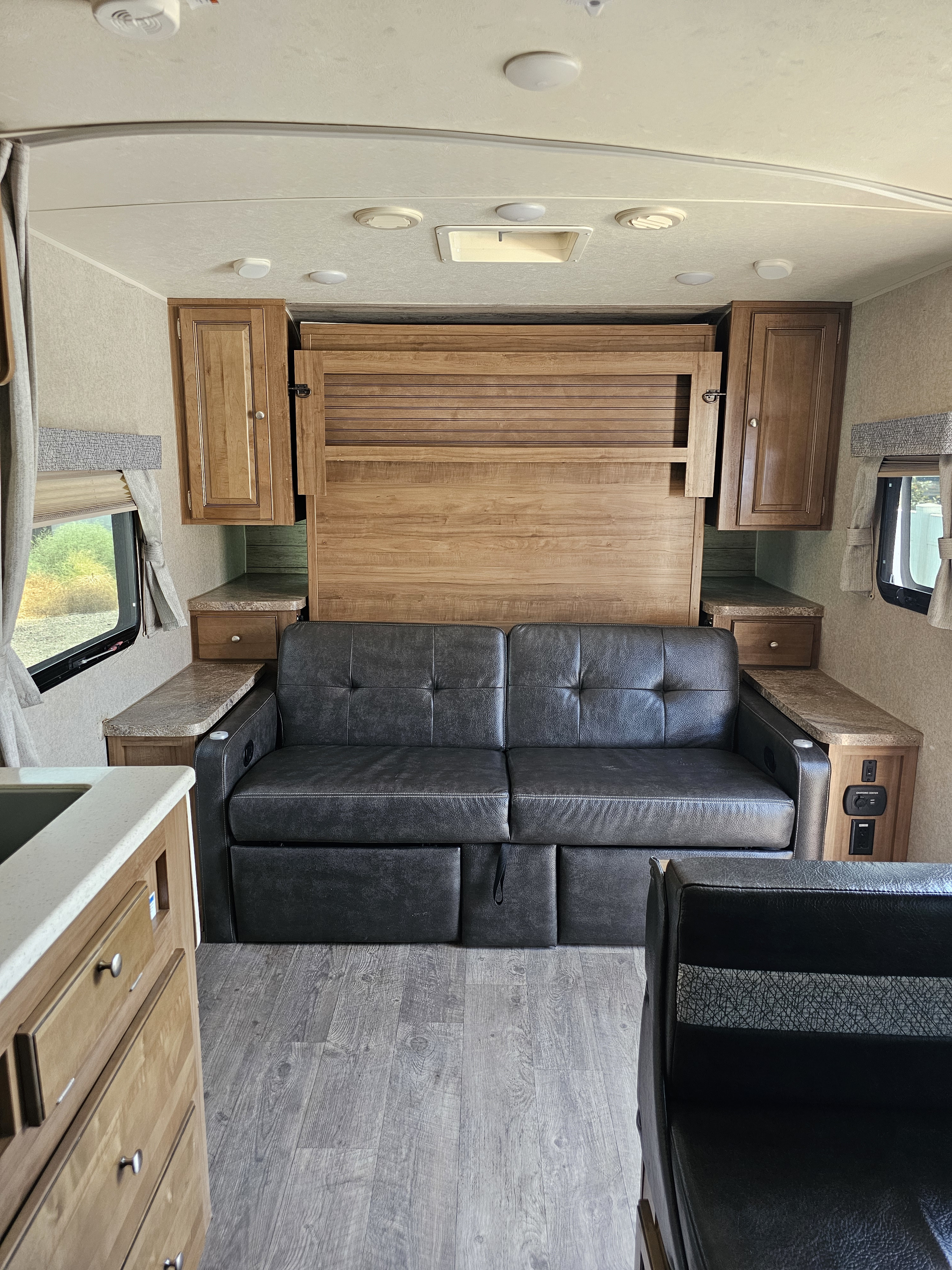 RV rental: Interior living area with gray convertible sofa/bed, wood cabinets, and counters. Compact and ready for adventure.. Forest River Rockwood Mini Lite 2018