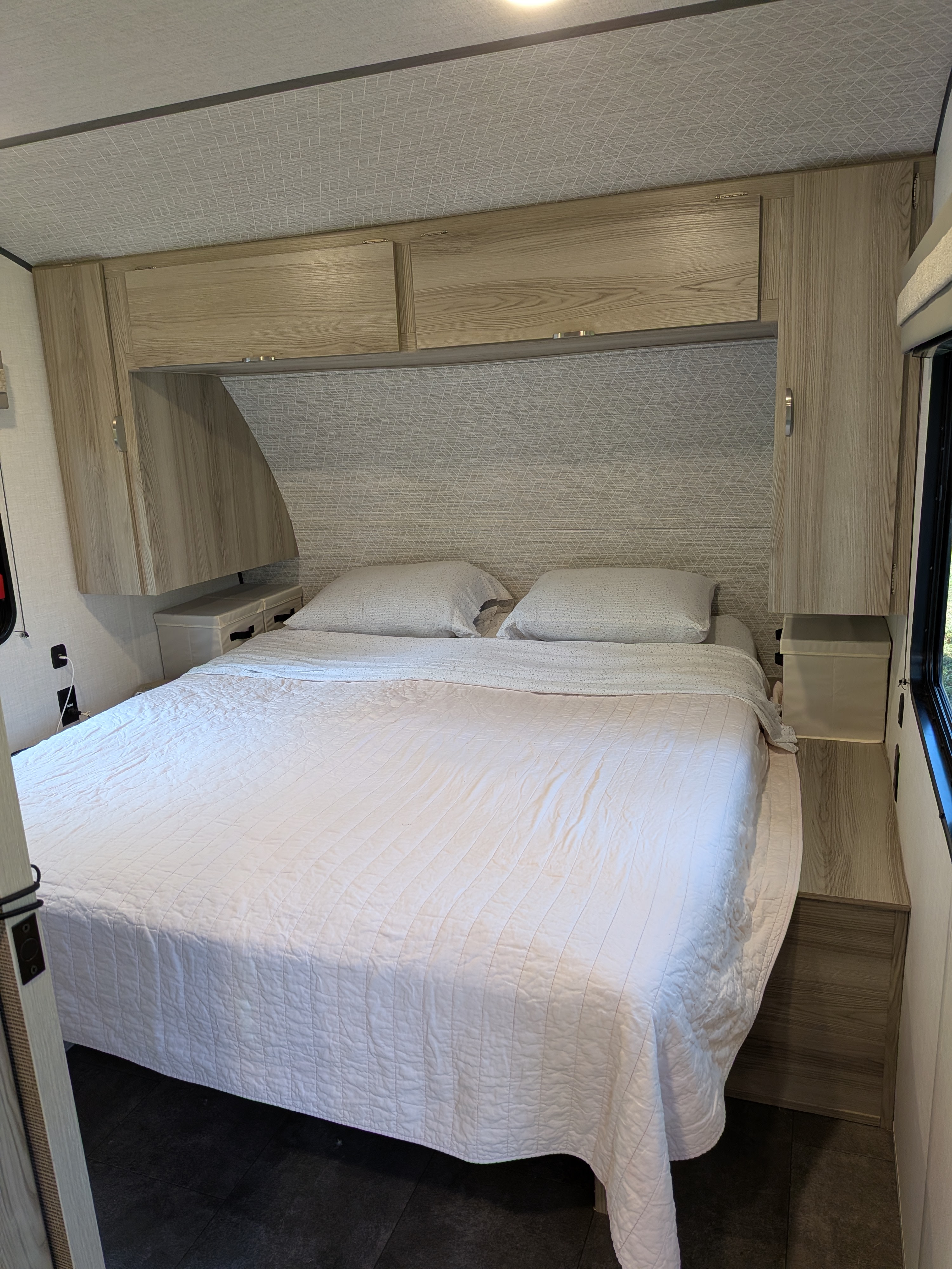 This RV rental bedroom features a comfy bed with white linens, light wood cabinets, and built-in storage solutions.. Forest River Salem FSX 266BHLE 2025