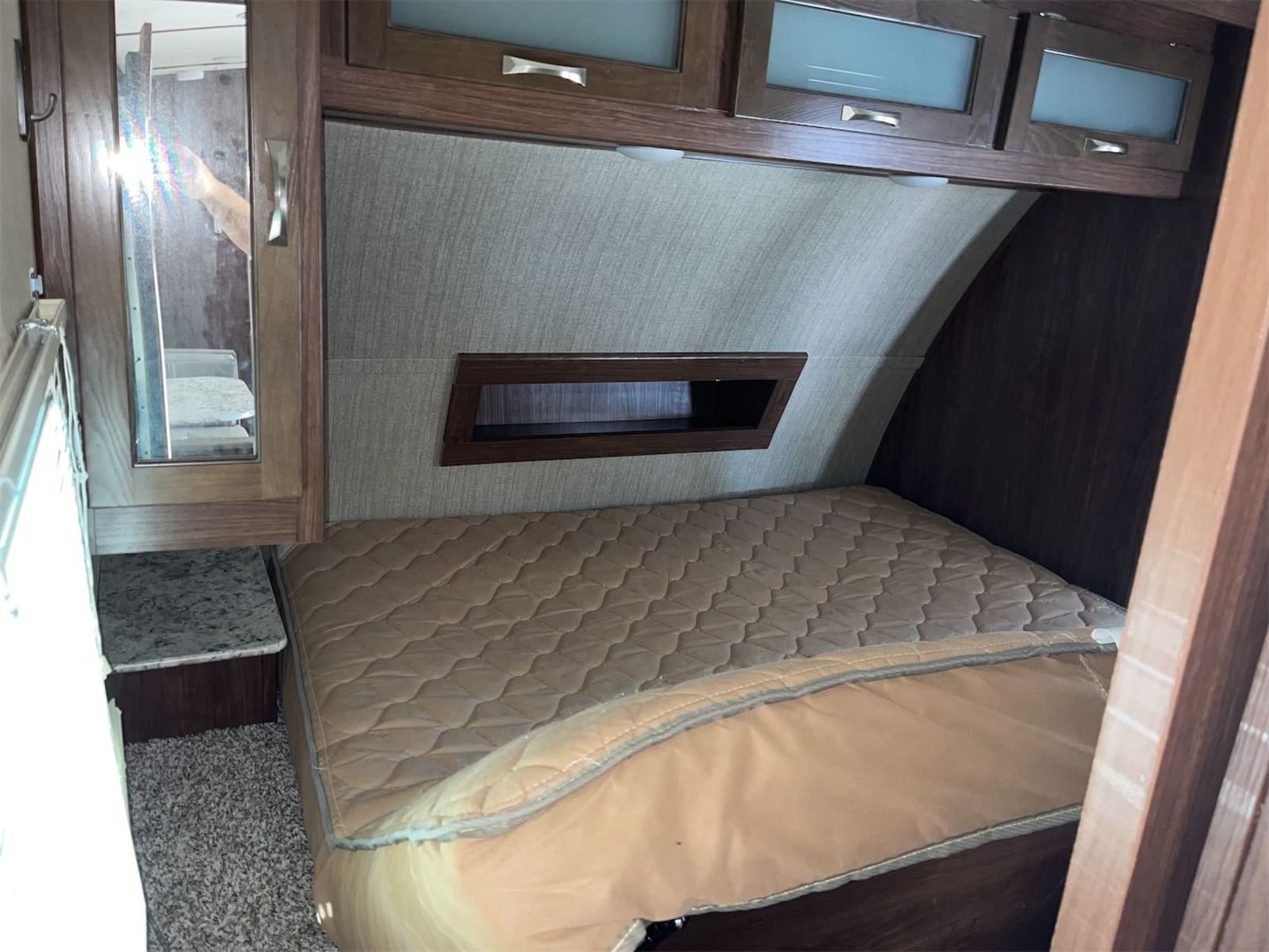 Step inside this cozy RV rental bedroom. Features include a comfortable bed, mirrored cabinet, and ample overhead storage.. Aerolite Aerolite Trailer 2018