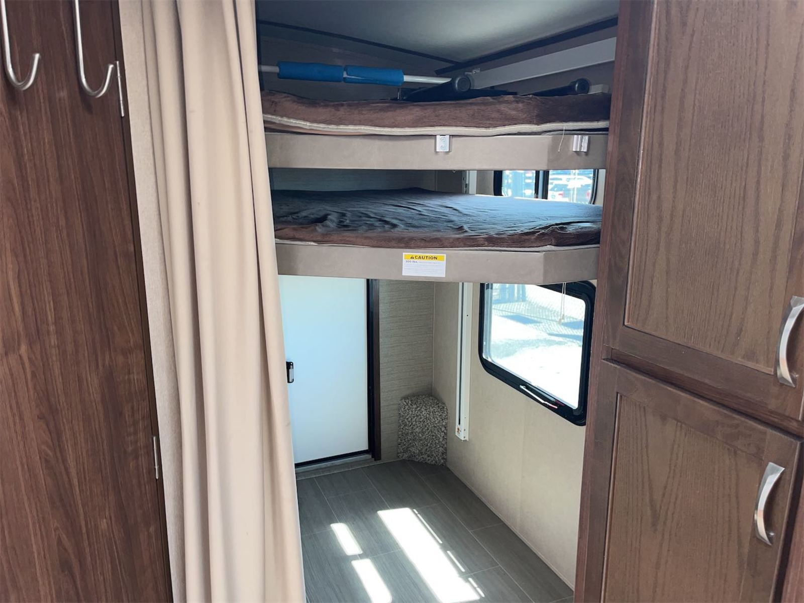 This RV rental features a cozy interior with bunk beds, a privacy curtain, and storage, ideal for family trips.. Aerolite Aerolite Trailer 2018